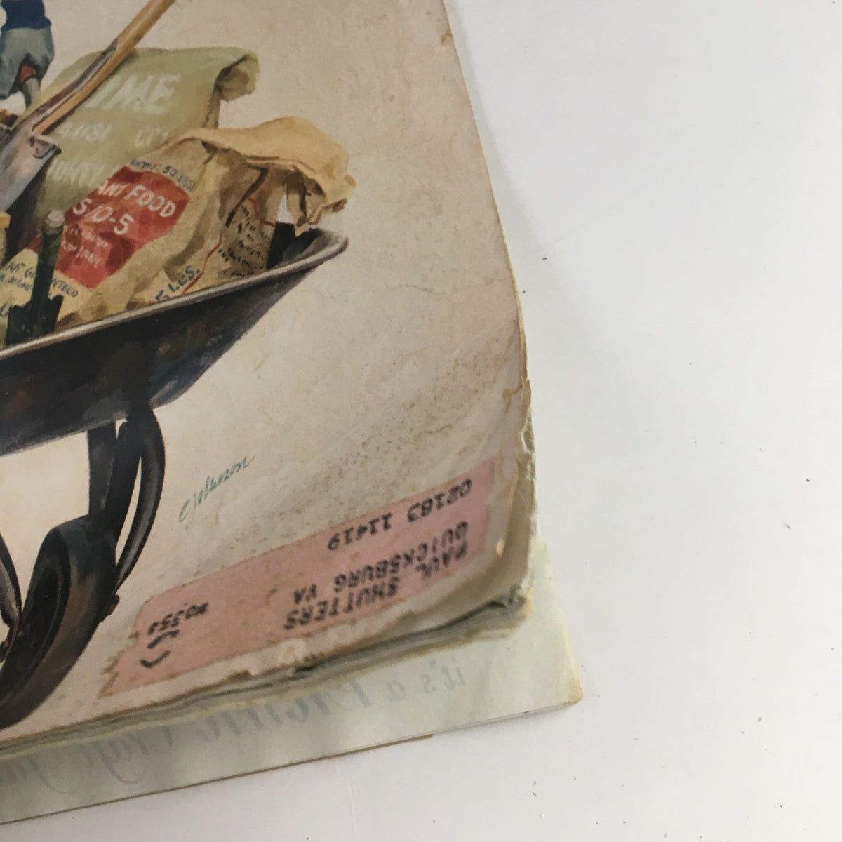 Close-up of the wheelbarrow featured on the cover of VTG Collier's Magazine April 4, 1953, showcasing various items including bags and tools.