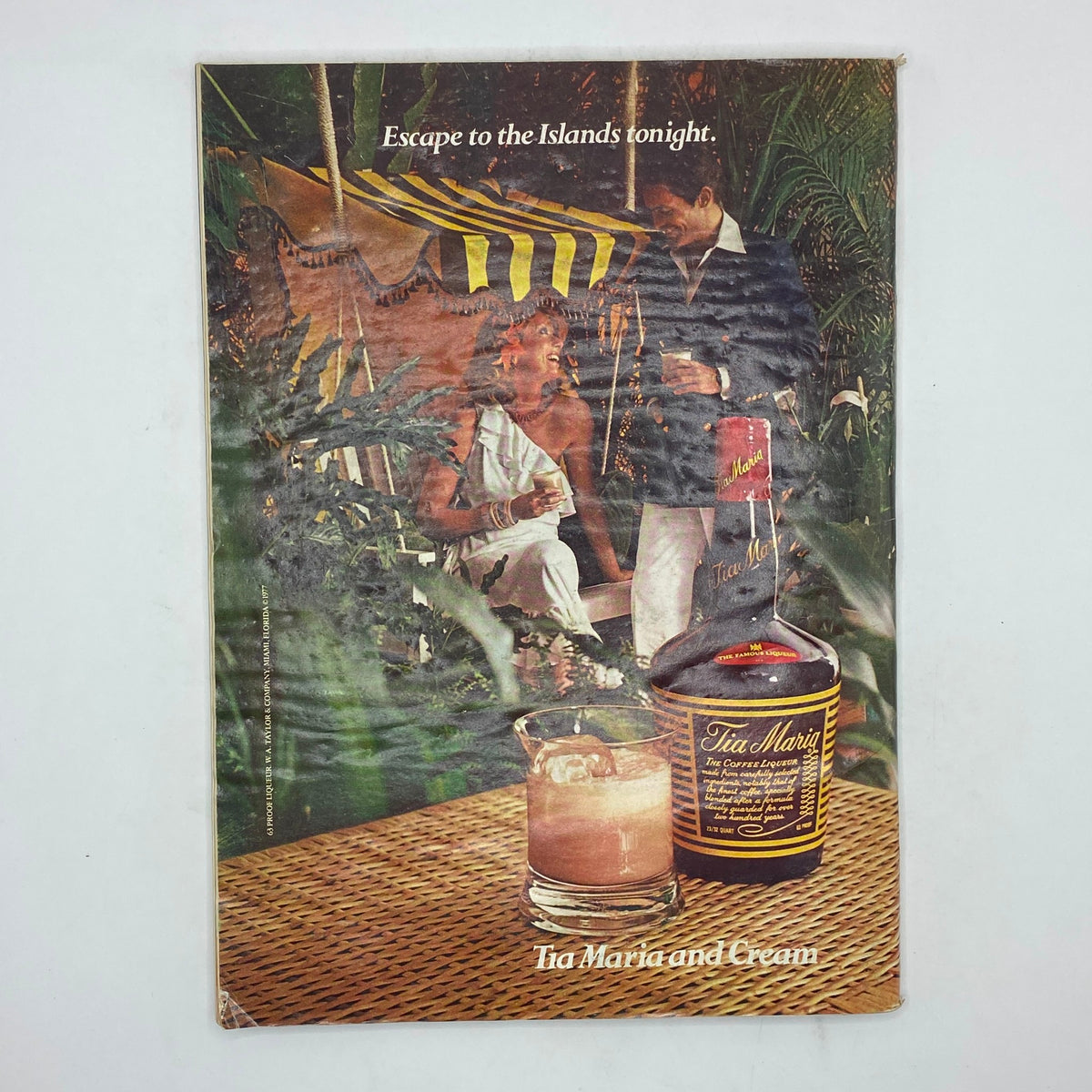 Back cover of The New Yorker magazine, December 5, 1977, featuring an advertisement for Tia Maria. The image depicts a tropical scene with a couple enjoying drinks, capturing the essence of leisure and escape.