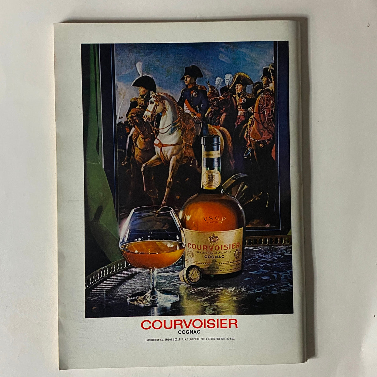 Courvoisier Cognac advertisement featuring a glass of cognac and a bottle, with historical figures in the background. The image emphasizes the luxury and heritage of Courvoisier. The New Yorker Complete Magazine April 15, 1974 Chas Addams Cover No Label VG.