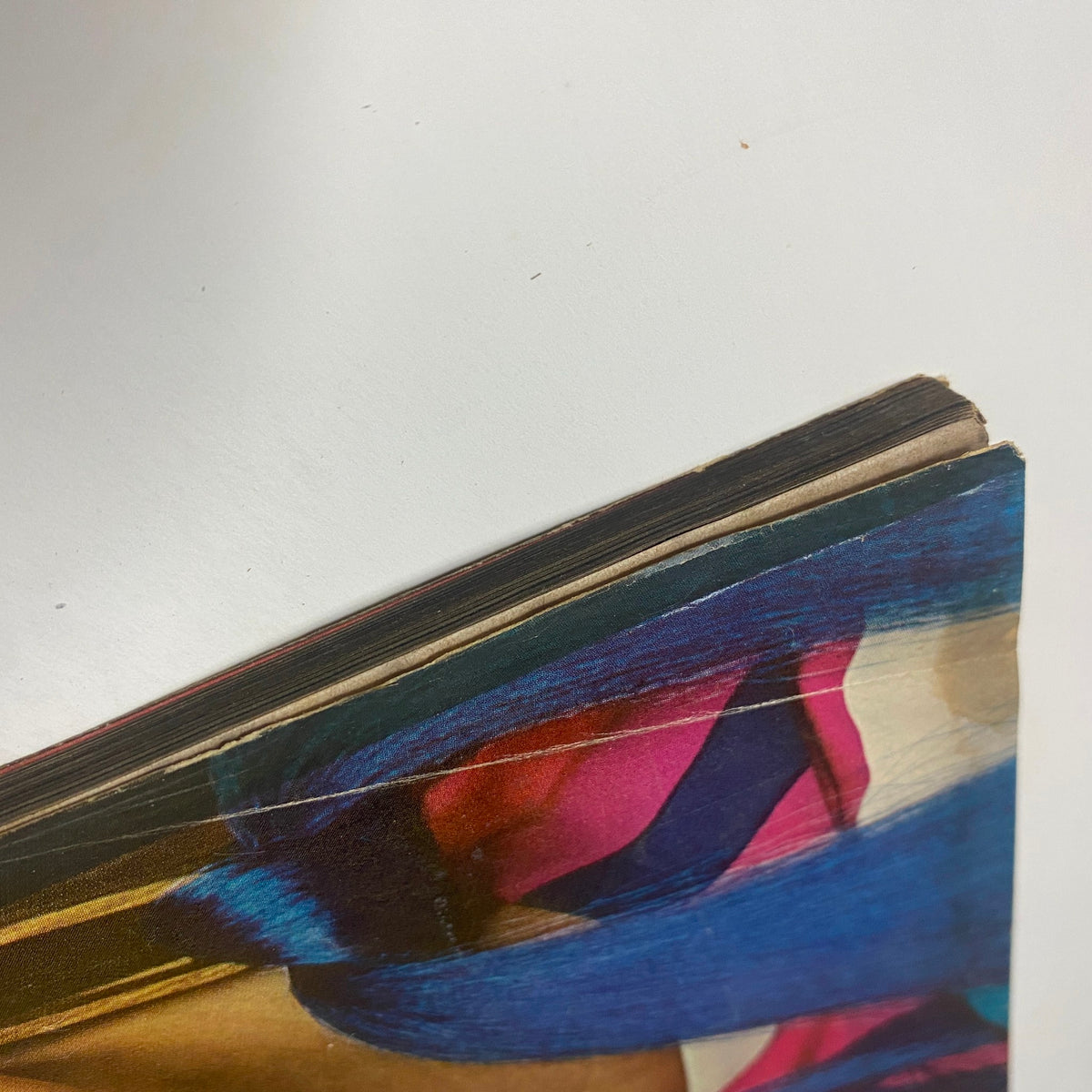 A close-up view of the edge of a vintage Vogue Magazine, showcasing the vibrant color splashes of its cover design. This is from the November 1, 1966 issue featuring Veruschka, photographed by Richard Avedon.