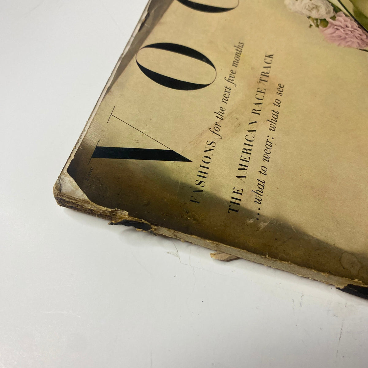 Close-up of the Vogue Magazine April 15, 1948 featuring the tagline about American racetracks, highlighting the vintage condition with noticeable wear on the edges.