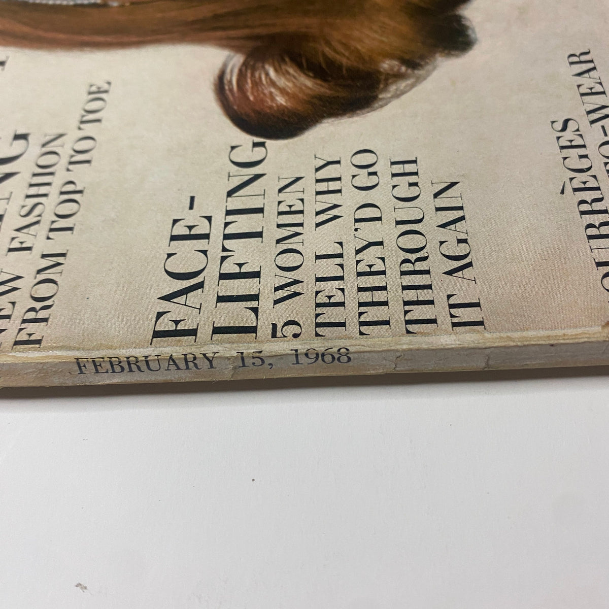 Close-up view of the bottom of the cover page of Vogue Magazine February 15, 1968, highlighting an article about face-lifting and the date.