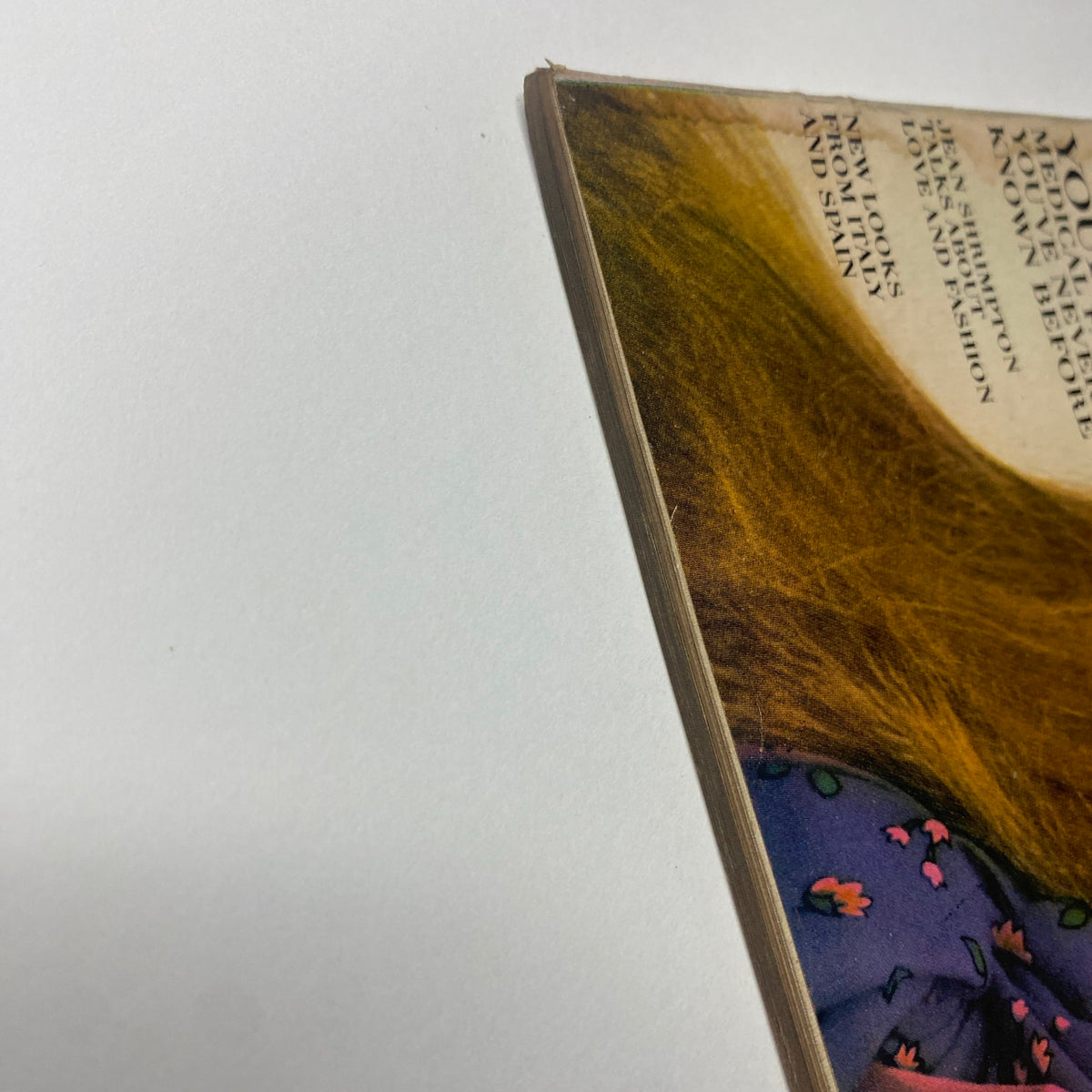Close-up of the spine of Vogue Magazine March 15, 1969, highlighting vintage wear and the worn characteristics of this collectible magazine.
