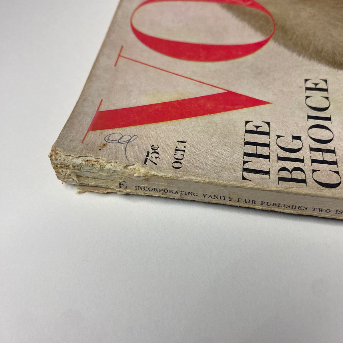 Detailed view of the spine of Vogue Magazine October 1, 1964, highlighting vintage wear and tear, emphasizing its collectible nature in fashion history.