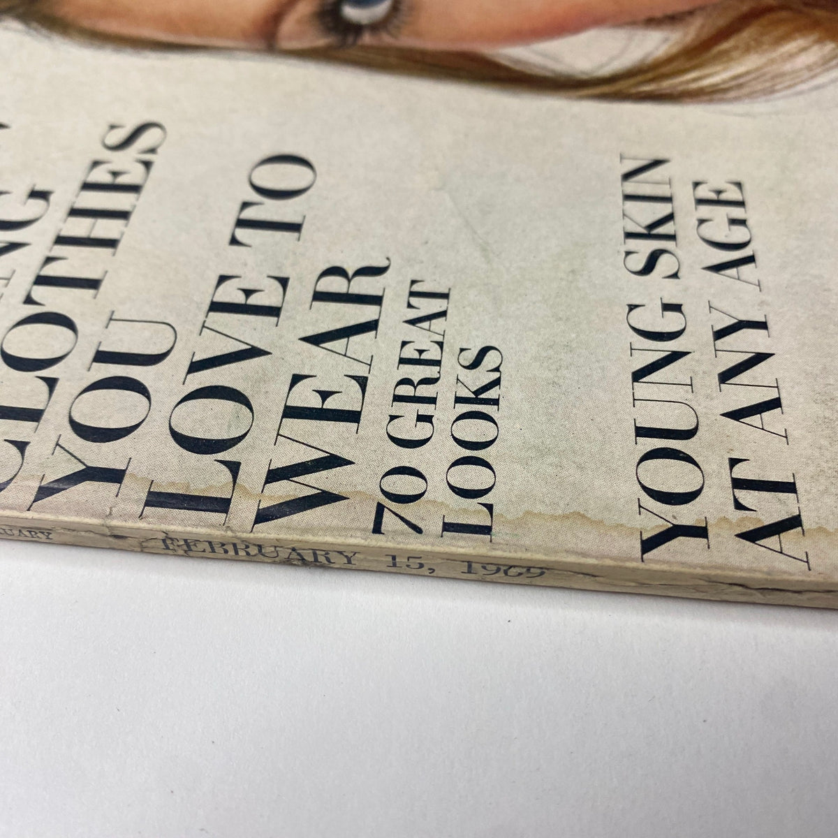 Close-up of the spine and publication date of Vogue Magazine February 15, 1969, showing signs of aging that reflect its historical significance.