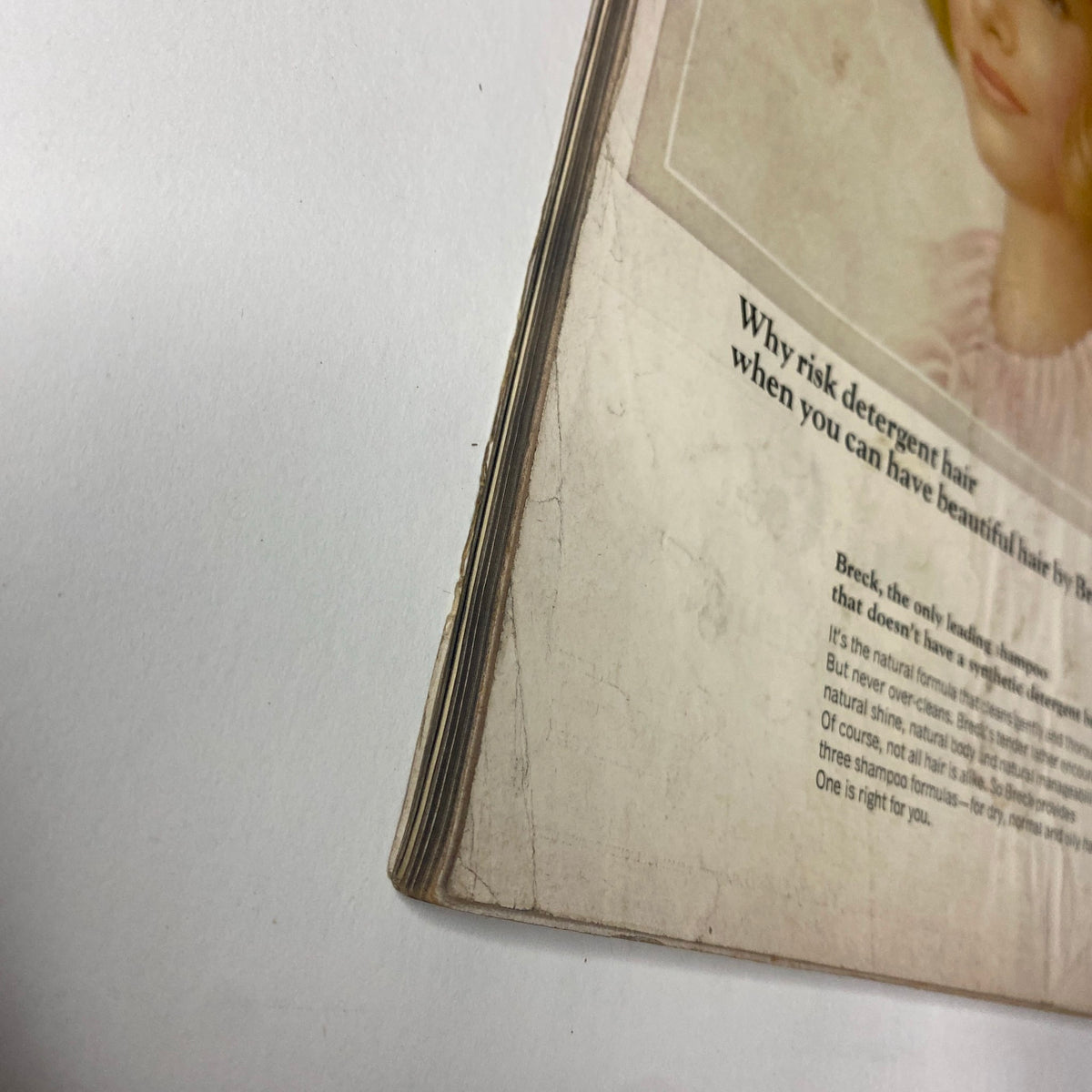 Close-up image of the spine of Vogue Magazine August 15, 1965, highlighting vintage wear and tear.