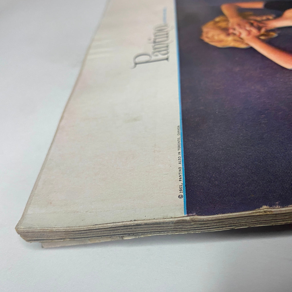 Side view of the Vogue Magazine April 15, 1961 displaying minor wear on the spine, emphasizing its collectible status and vintage character.