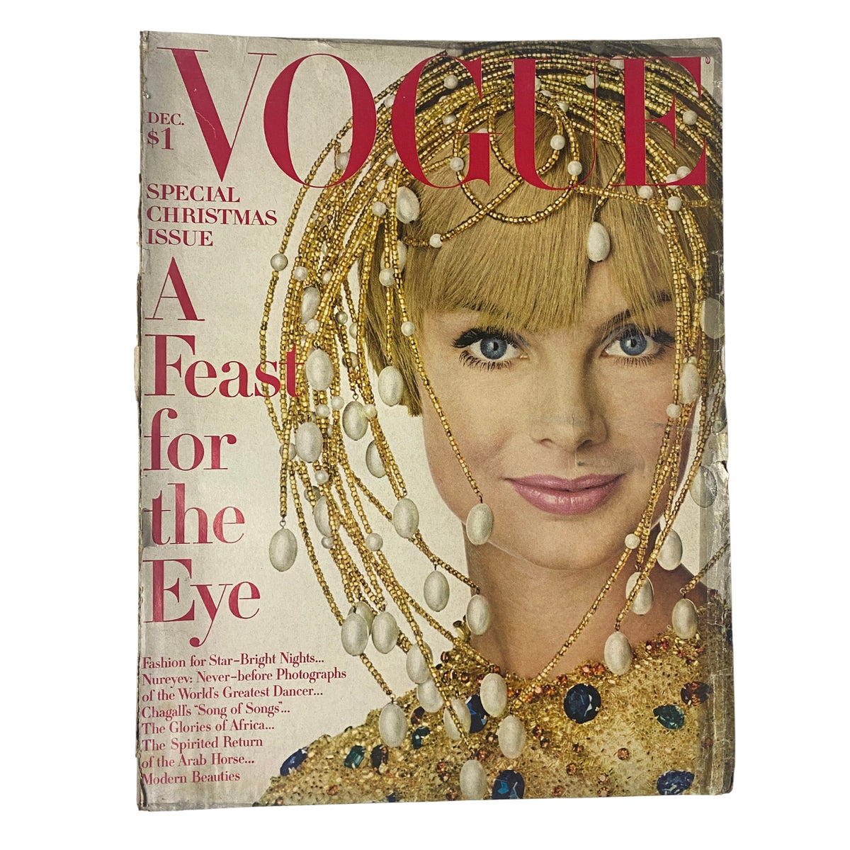 Vogue Magazine December 1967 Jean Shrimpton Cover by Irving Penn featuring a model adorned with elaborate jewelry and makeup, titled 'A Feast for the Eye'. This special Christmas issue showcases a blend of fashion and culture.