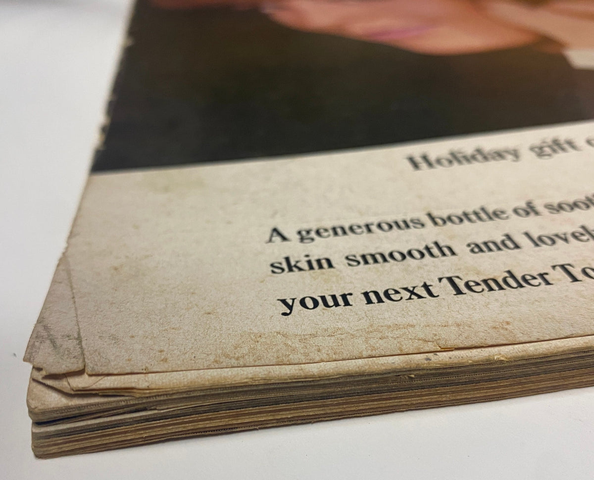 Close-up of the spine of a vintage Vogue Magazine November 15, 1964, displaying wear and tear that reflects the magazine's history and authentic vintage character.