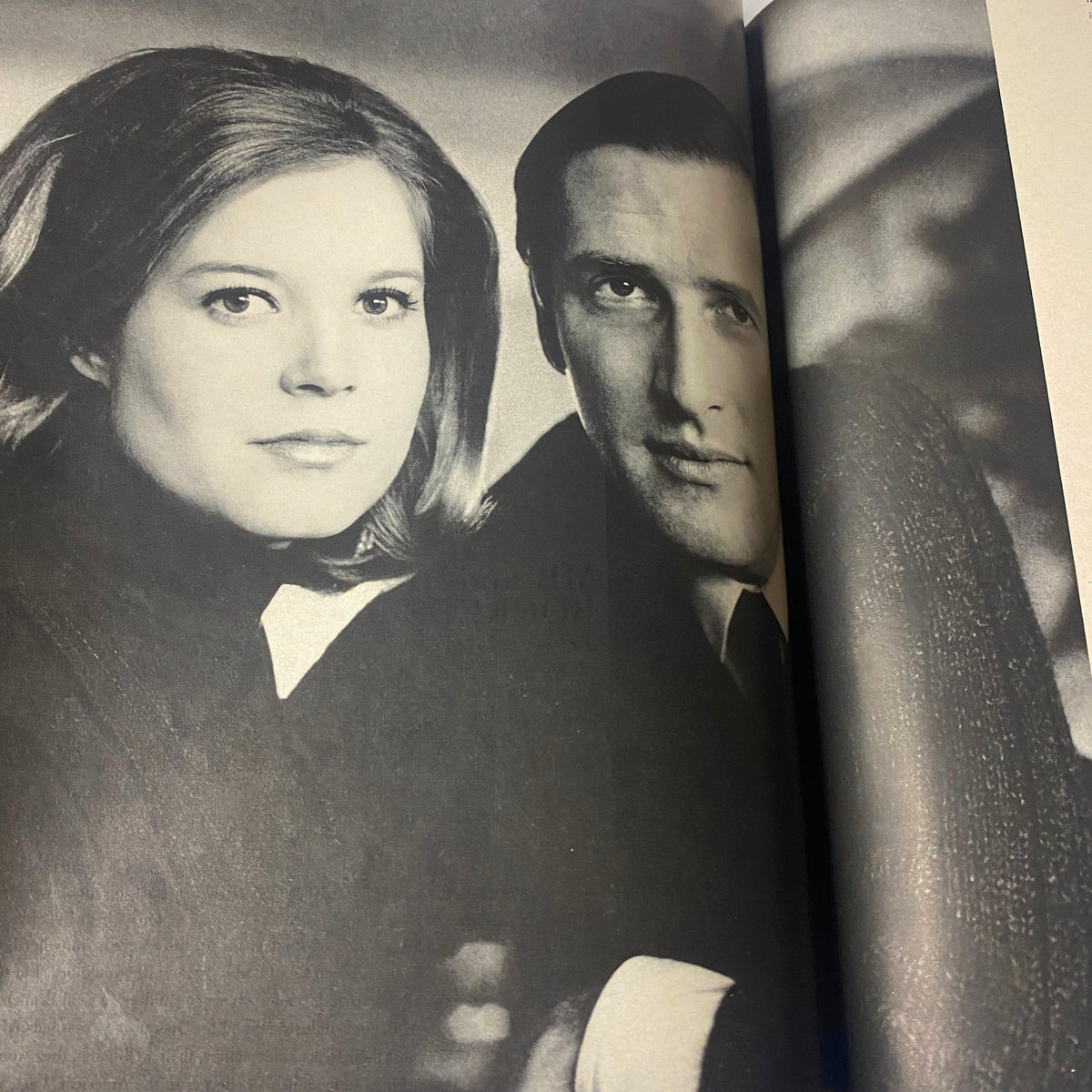 A black and white photograph of a couple in Vogue Magazine May 1969, reflecting the fashion and culture of the late 1960s. This image showcases social interactions and style typical of the era.