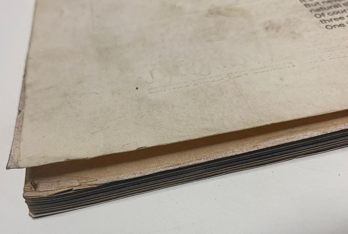 Close-up view of the spine of Vogue Magazine January 15, 1965, showing vintage wear and tear, characteristic of collectible magazines from the mid-20th century.