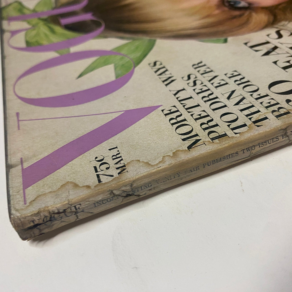 Close-up of the spine of Vogue Magazine March 1, 1969, showing age-related wear with visible black residue and detailing of the magazine title.