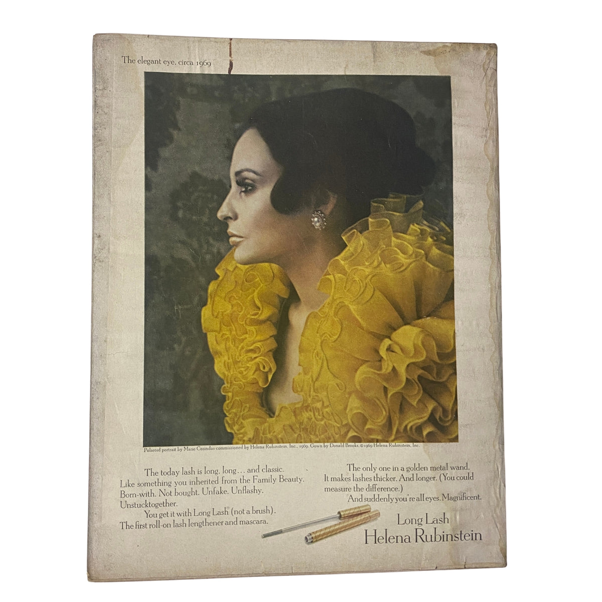 Vintage advertisement featuring a model wearing a yellow ruffled dress, promoting Long Lash by Helena Rubinstein. The image is from the Vogue Magazine March 1, 1969, issue with a cover by Irving Penn showcasing Sue Murray. A stylish representation of 1960s beauty and fashion.