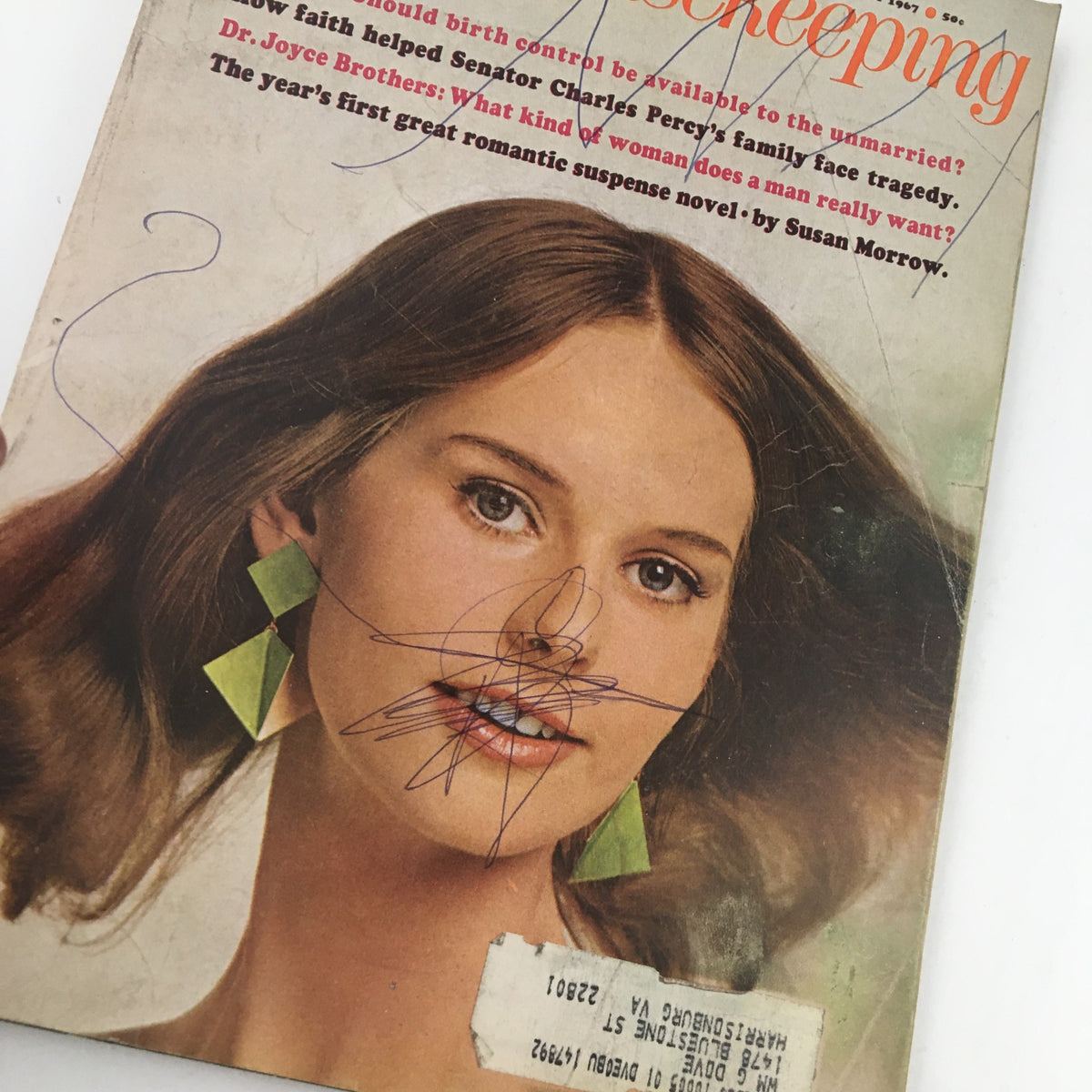 Close-up of the cover of Good Housekeeping Magazine February 1967, showcasing a woman with green earrings, reflecting on the magazine's focus on societal themes and personal stories.