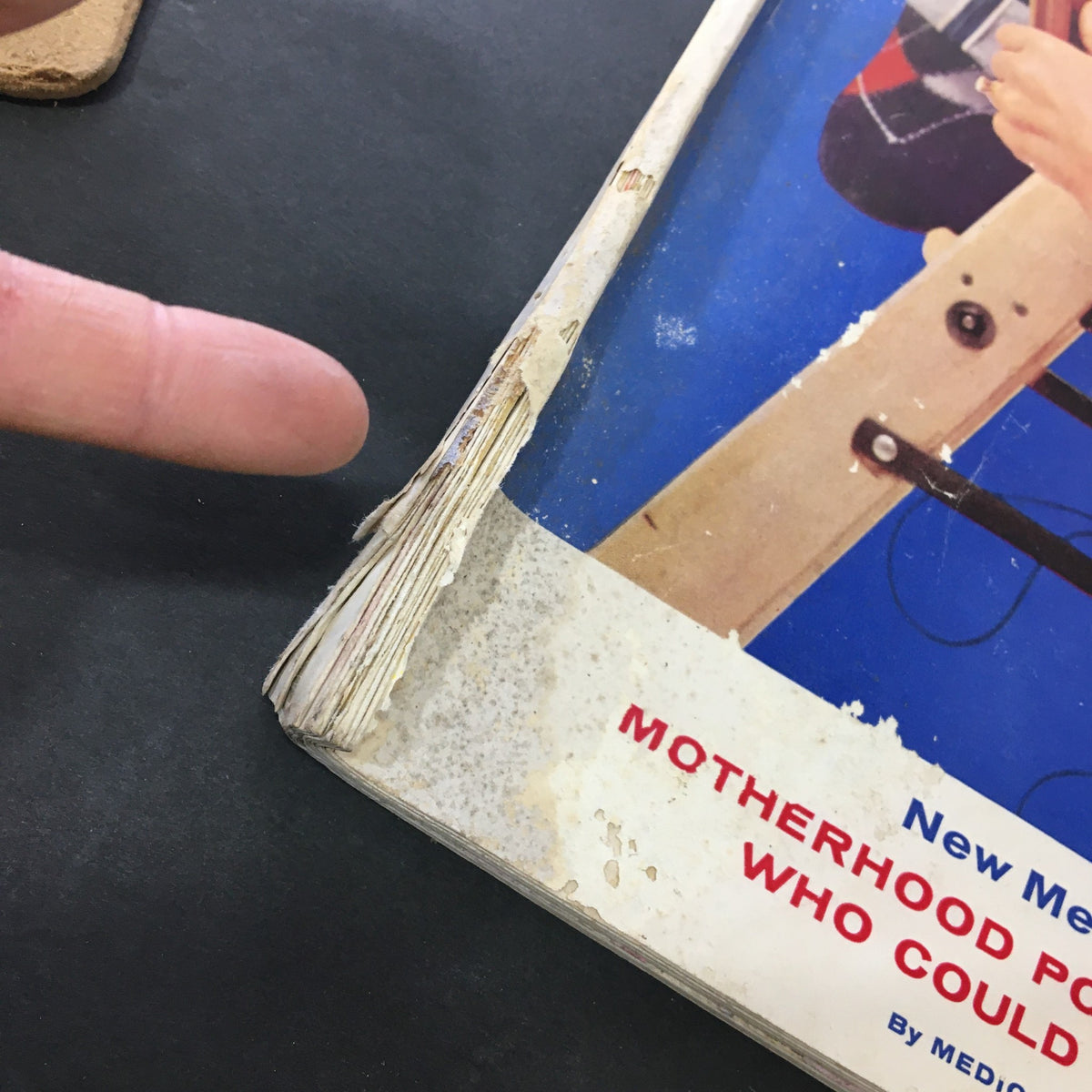 Close-up of the spine of the VTG Journal Magazine August 1957, revealing wear and damage, emphasizing the magazine's vintage condition and historical significance.