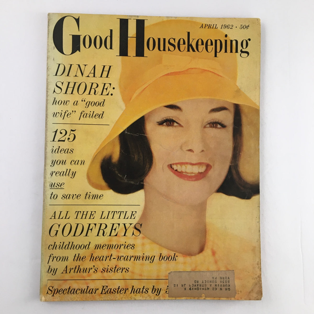 Cover of Good Housekeeping Magazine, April 1962, featuring the title 'Good Housekeeping,' a smiling woman in a yellow hat, and the text 'All The Little Godfreys Childhood Memories.' The magazine promotes 125 time-saving ideas for women.