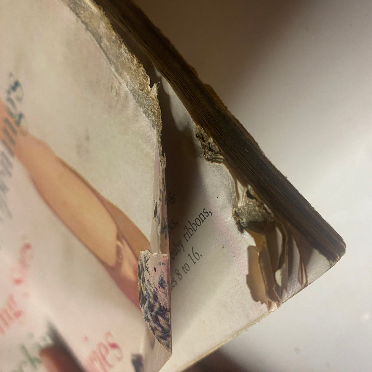 Damaged corner of the Harper's Bazaar Magazine March 1955, illustrating the magazine's vintage condition, essential for collectors of historical fashion publications.