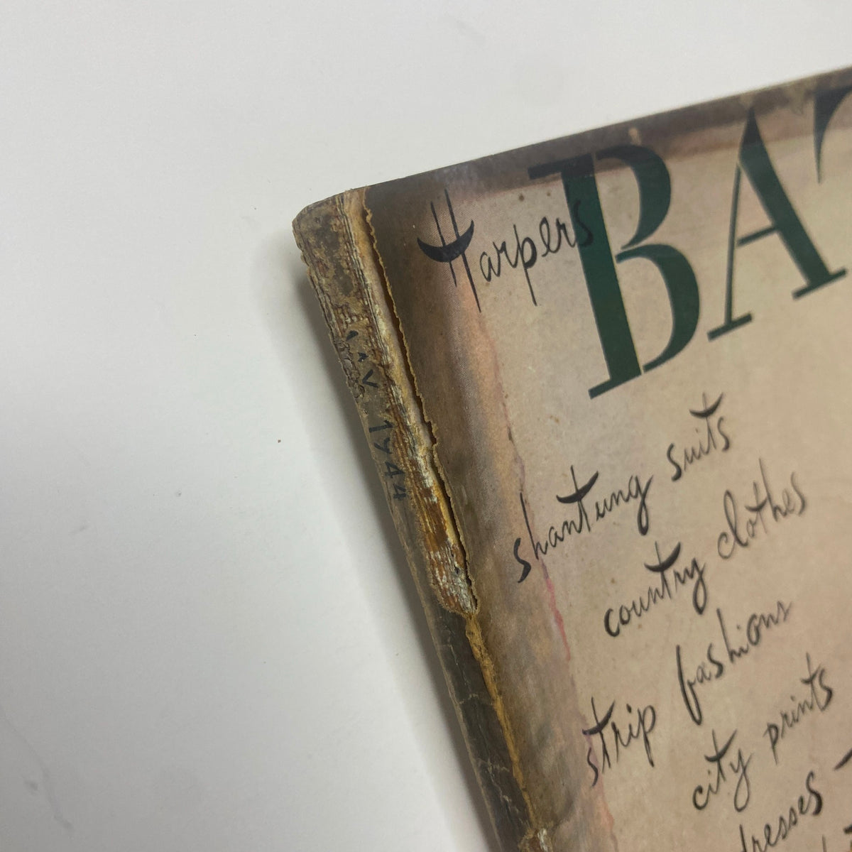 Close-up of the edge of the May 1944 Harper's Bazaar Magazine showing wear and tear, emphasizing its vintage collectible status.