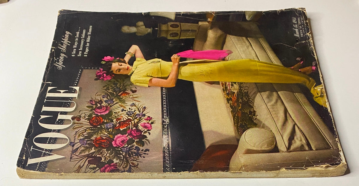 An angled view of Vogue Magazine March 15, 1941, displaying Laurie Douglas dressed in a yellow gown, surrounded by a floral motif, representing mid-century fashion publishing.