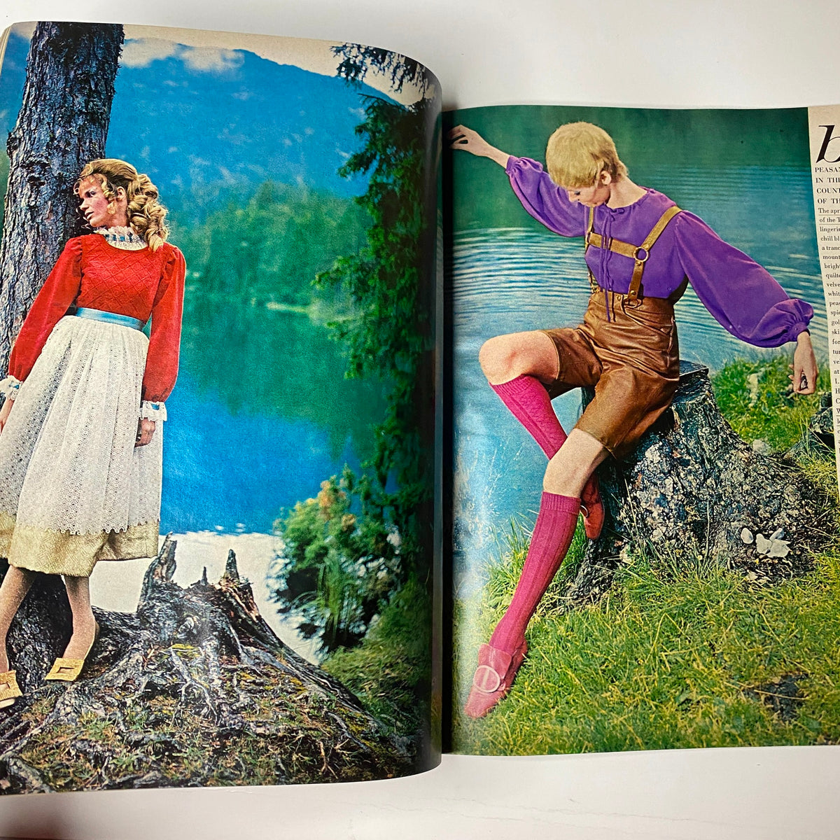 Vogue Magazine October 15, 1967, showcasing two models: one in a vibrant red top with a white skirt and the other in a purple blouse with brown shorts, set against a scenic lakeside background.