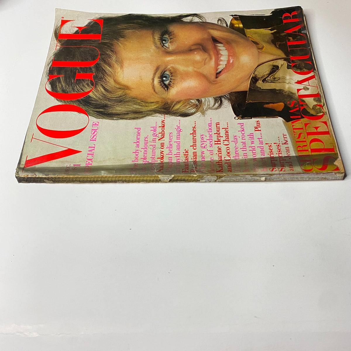 Side view of the vintage Vogue Magazine December 1969 showing the front cover with a smiling model, bold red font of the title 'VOGUE', and the text 'CHRISTMAS SPECTACULAR', reflecting its special holiday issue status.
