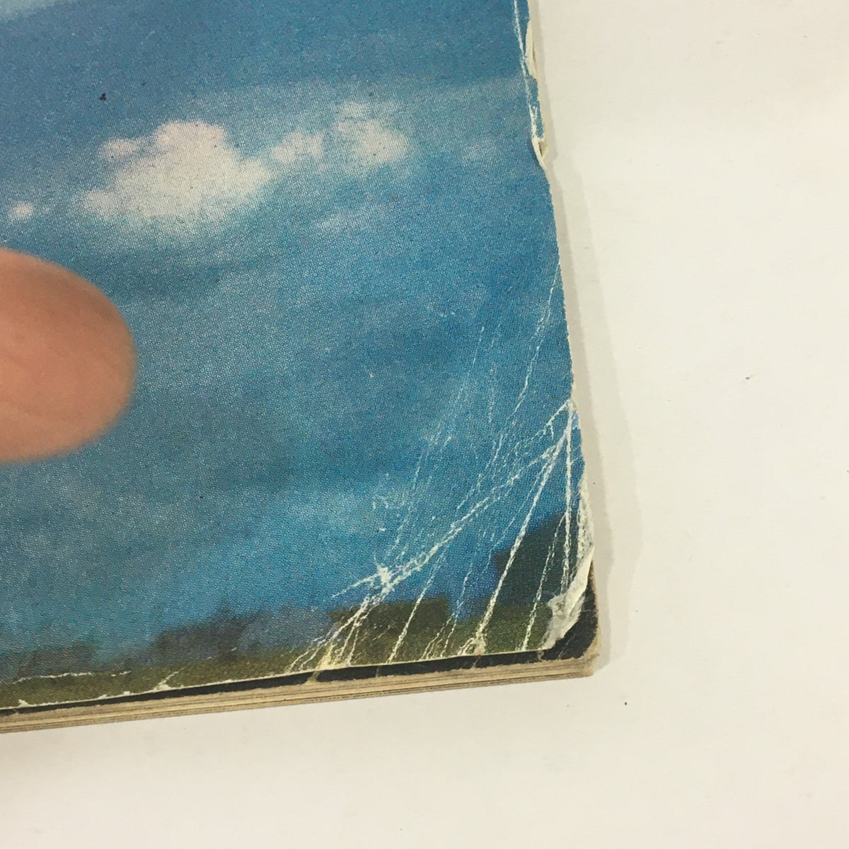 Close-up image of the edges of the Vintage Sports Illustrated Magazine from August 17, 1964, showing some wear and minor creases alongside a blue sky background.