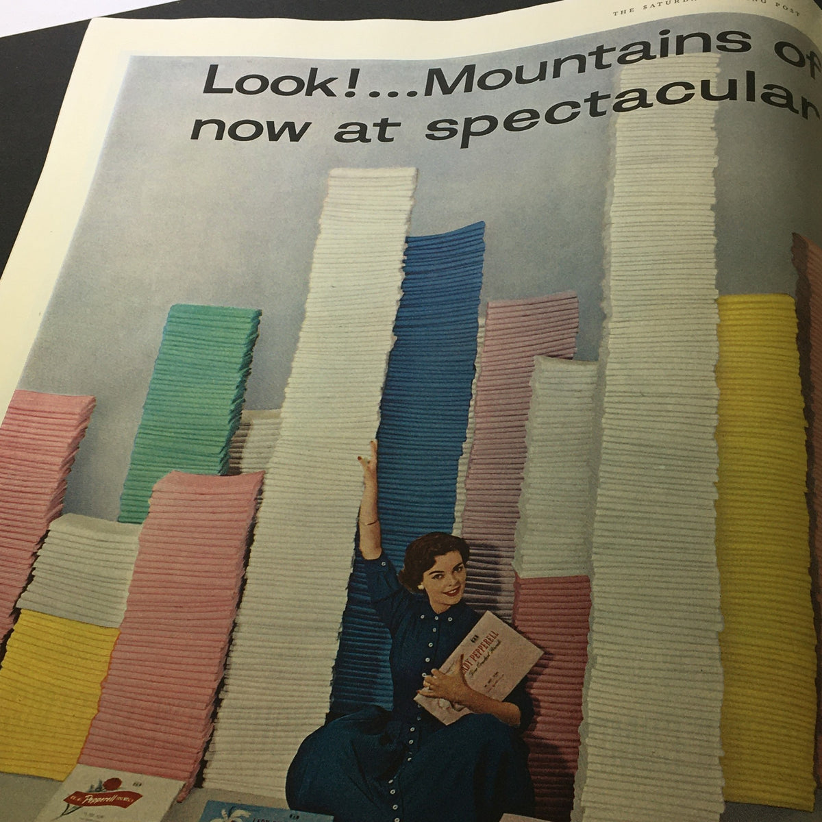 Advertising page in VTG The Saturday Evening Post December 29 1956 featuring colorful stacks of fabric, promoting products with the headline 'Look! ... Mountains of now at spectacular'.
