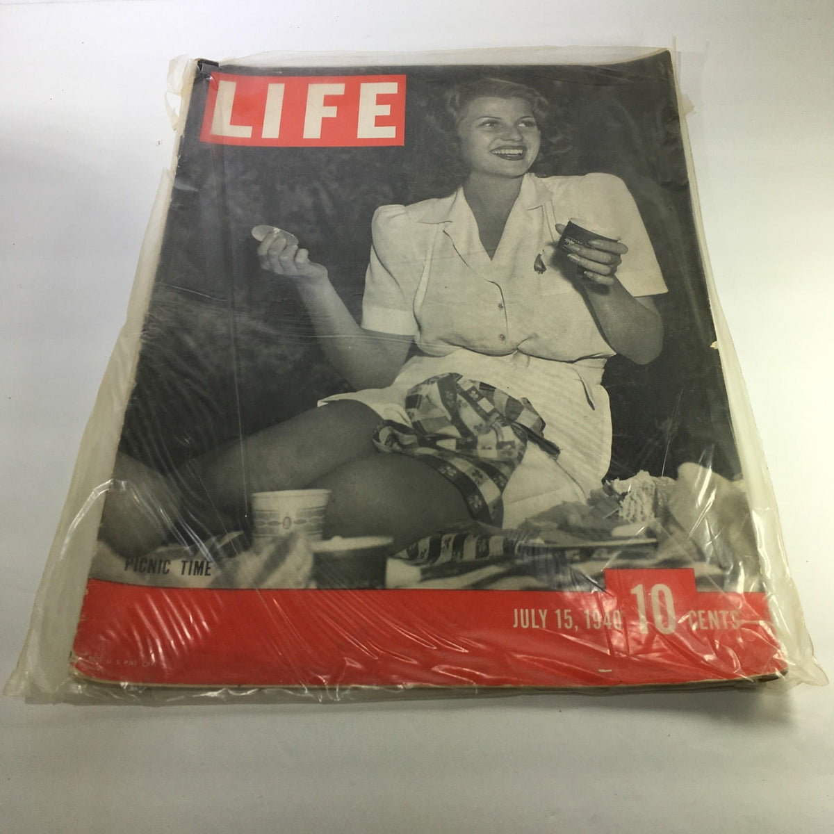 Life Magazine cover from July 15, 1940, titled 'Picnic Time'. The cover features a smiling woman holding a cup, dressed in a white blouse, with a picnic scene in the background, embodying the essence of summer leisure.