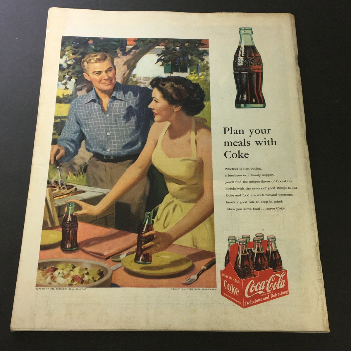 Vintage Coca-Cola advertisement in The Saturday Evening Post July 11 1953, illustrating a couple enjoying a meal outdoors with bottles of Coke.