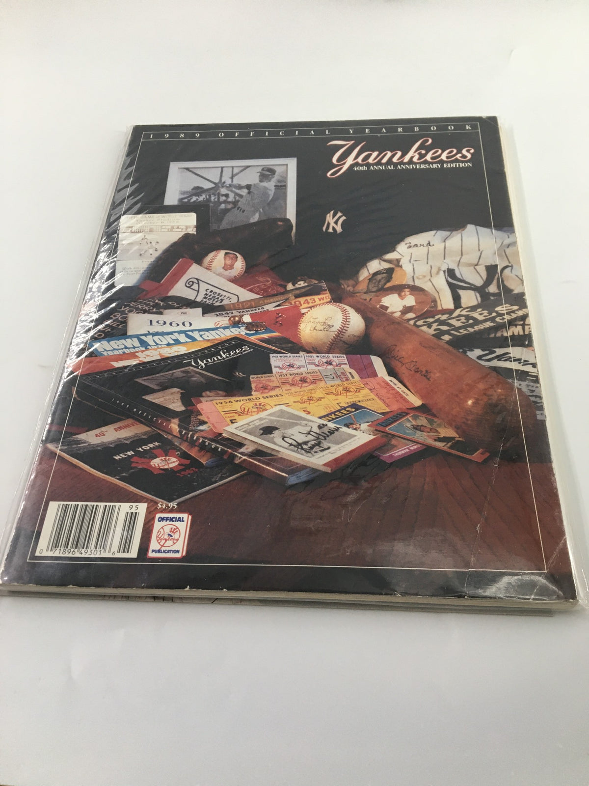 1989 Official Yearbook New York Yankees featuring vintage sports memorabilia, showcasing items like baseballs, magazines, and player statistics, preserved in protective plastic.