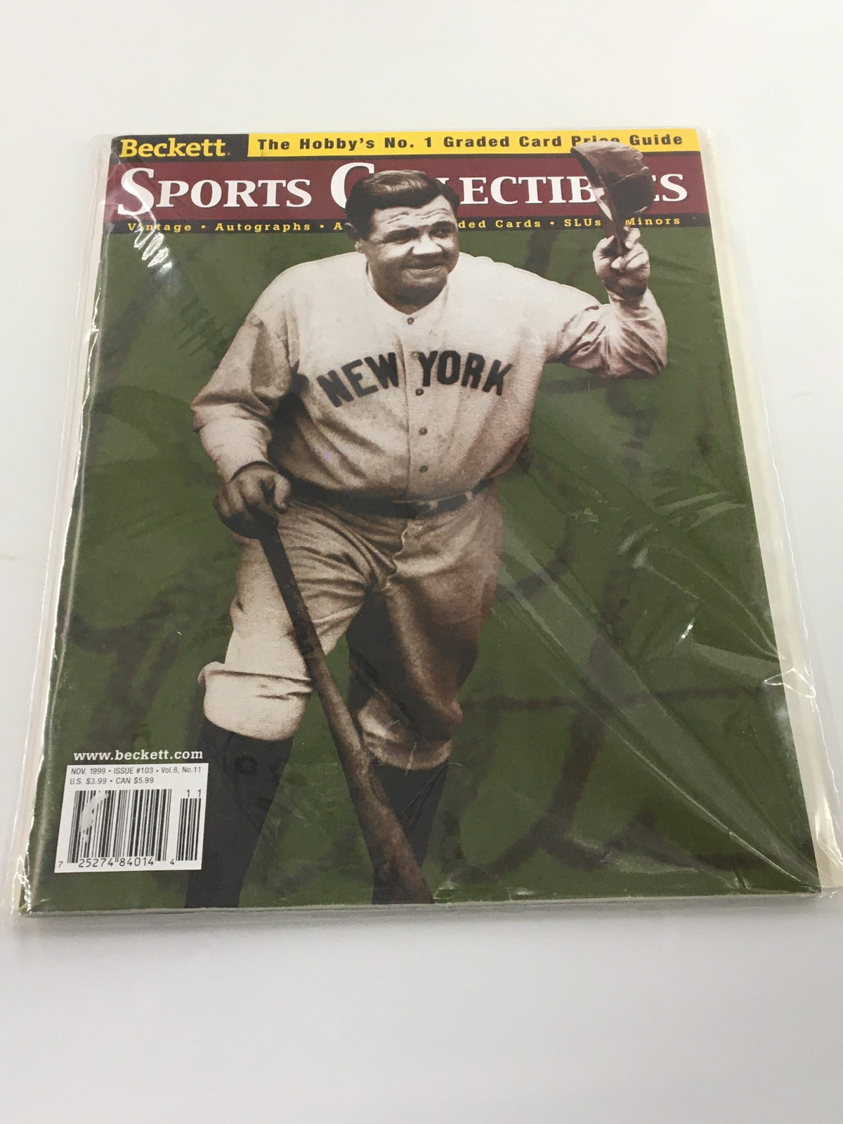 Beckett Sports Collectibles November 1999 issue #103 front cover featuring Babe Ruth, a legendary baseball figure, in a protective plastic sleeve.