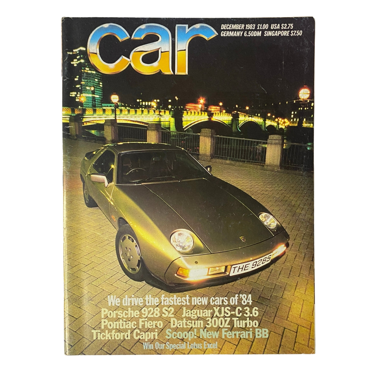 Cover of Car Magazine UK December 1983 featuring Porsche 928 S2, Jaguar XJS-C 3.6, and Pontiac Fiero. The image showcases a Porsche 928 S2 parked in front of a picturesque cityscape, emphasizing the magazine's focus on the latest car models and automotive culture.