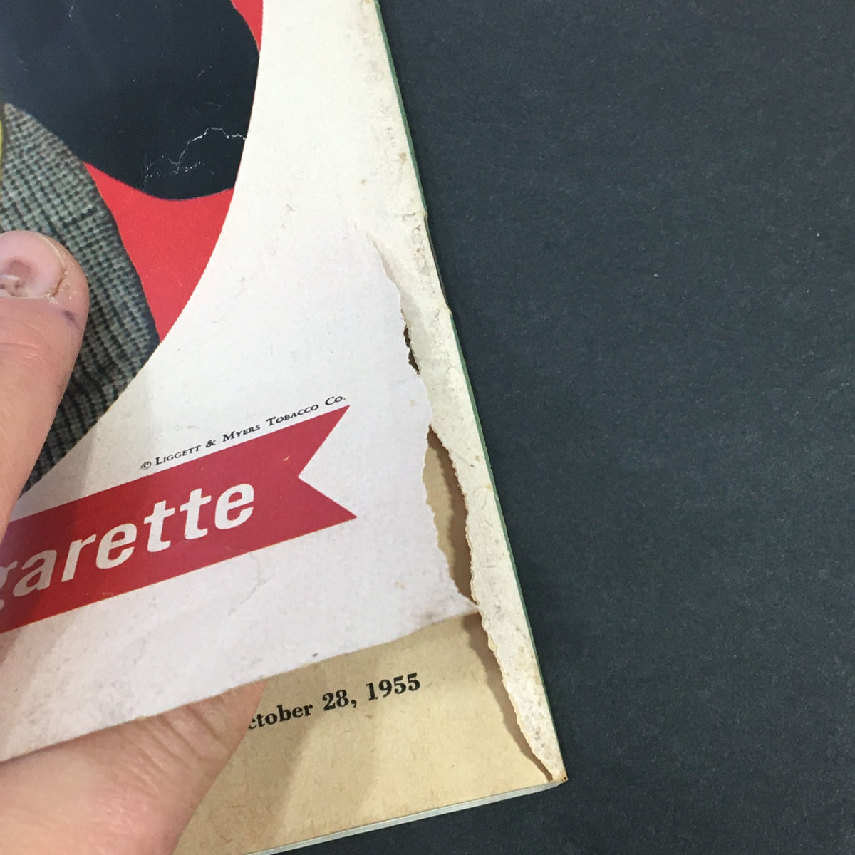 Close-up of the vintage Collier's Magazine from October 28, 1955, showing a detail of wear on the edge with a torn area, highlighting the original newsstand condition.