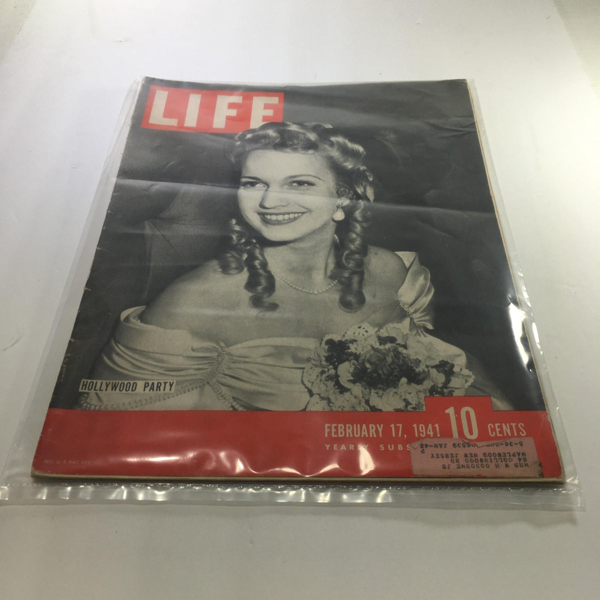Cover of Life Magazine: February 17, 1941 - Hollywood Party edition featuring a smiling woman with curly hair, wearing a formal dress and holding a bouquet, highlighting the glamour of early 1940s Hollywood.