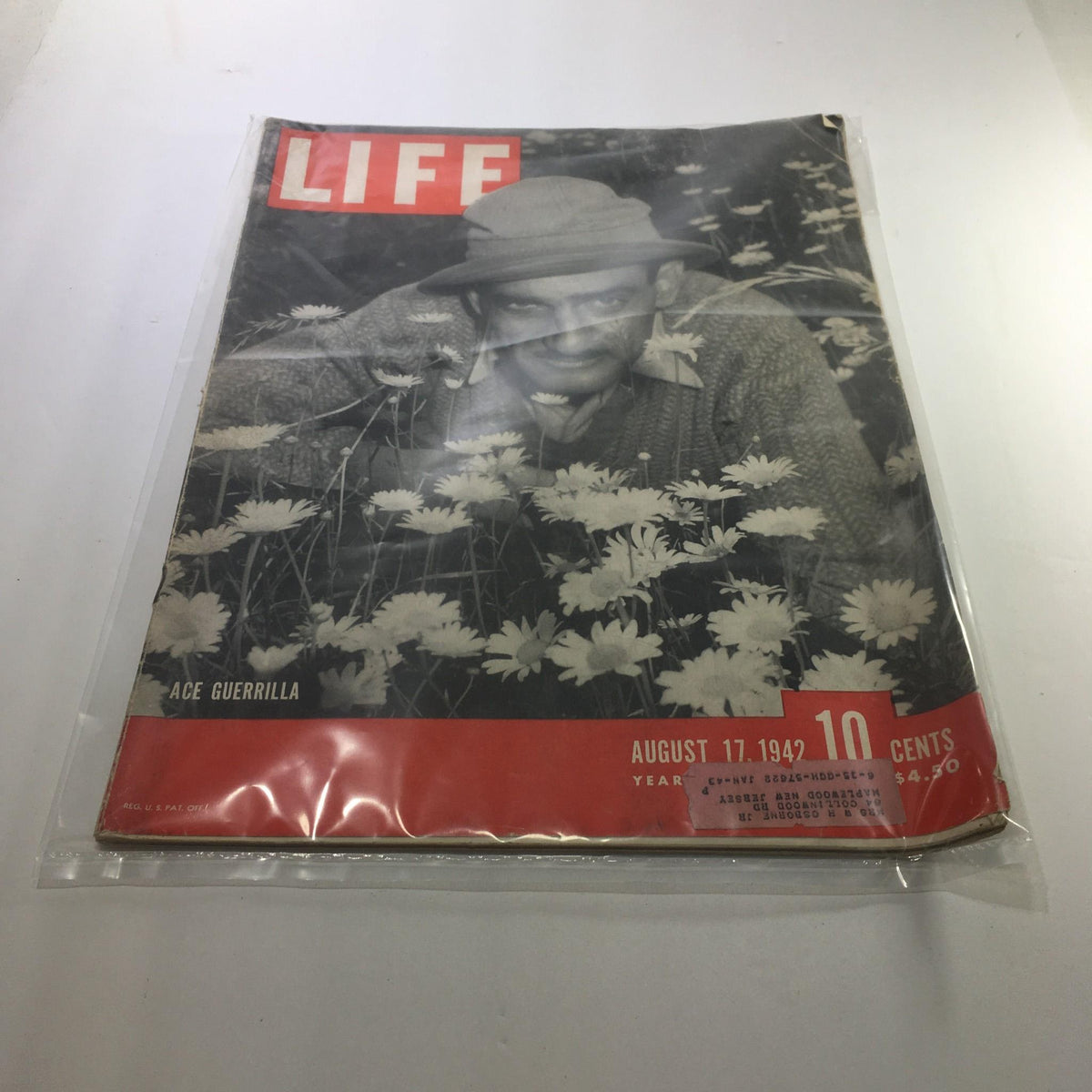 Cover of Life Magazine dated August 17, 1942 featuring the title 'Ace Guerilla', depicting a man surrounded by flowers, showcasing the resilience during World War II.