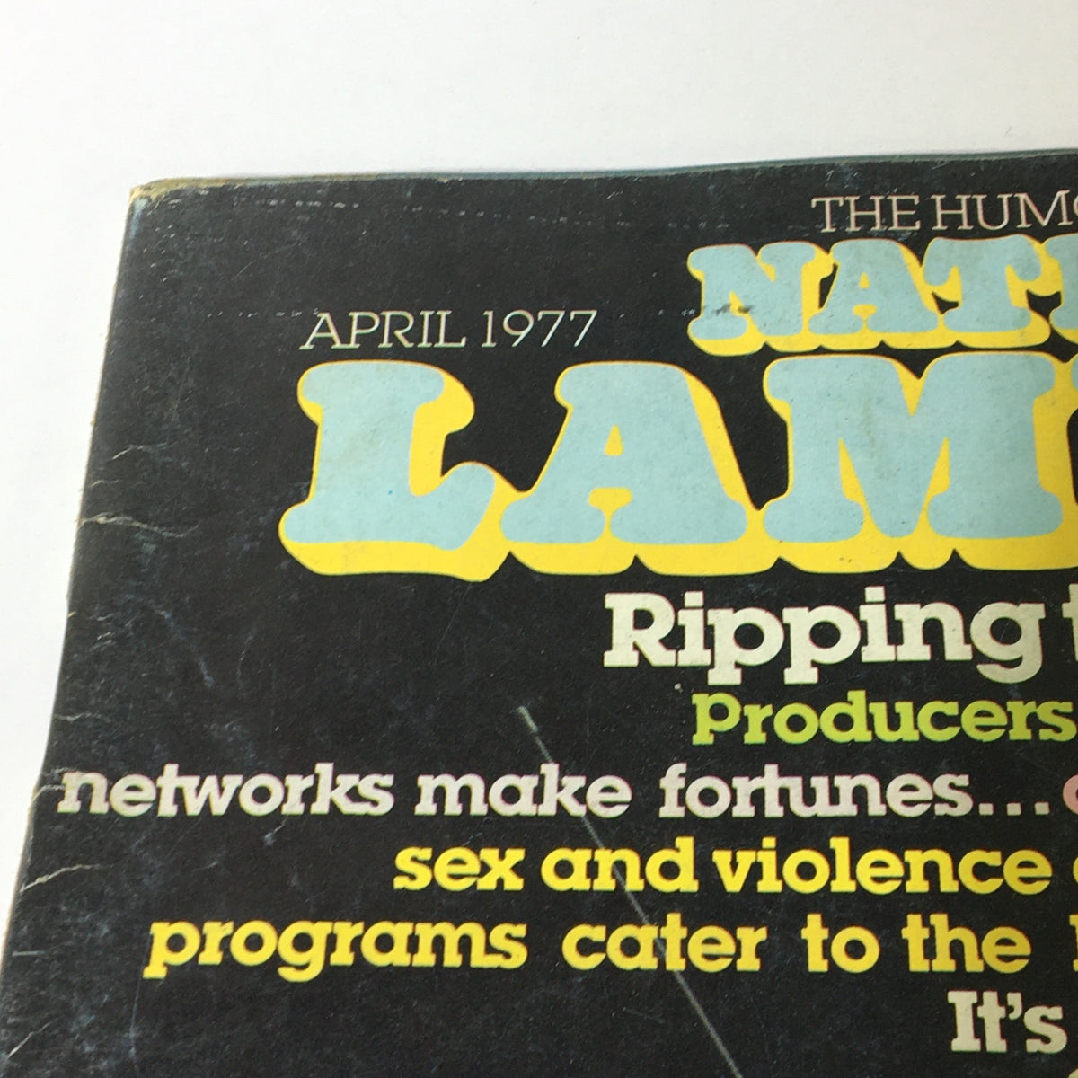Cover of National Lampoon Magazine April 1977 featuring bold title and humorous tagline about television producers and programming, showcasing a vintage magazine aesthetic.
