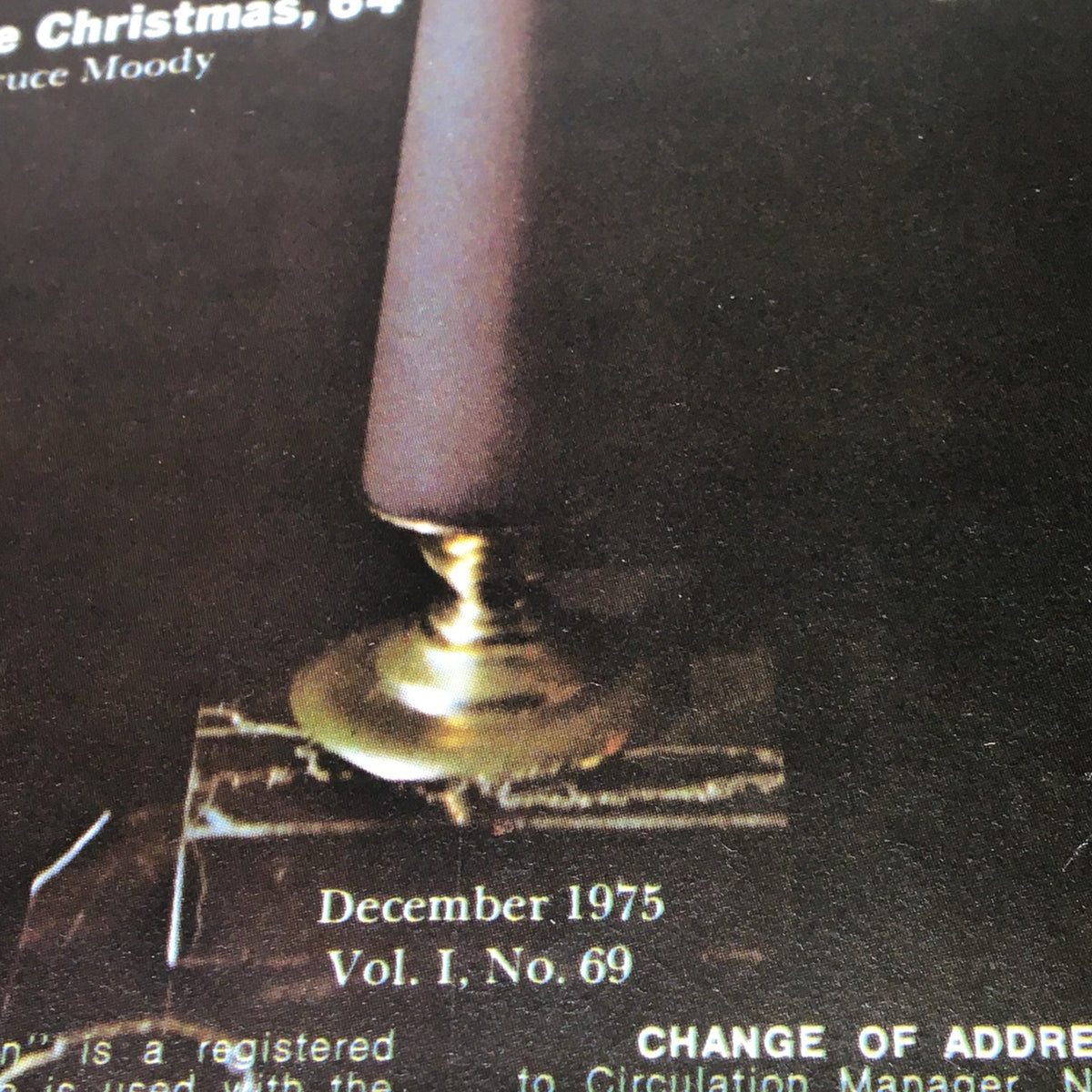 Close-up image of National Lampoon Magazine December 1975, Vol 1, No 69, featuring details of the magazine's cover, including a candle holder and the issue date. This iconic vintage magazine covers the theme 'Guide to Effective Salesmanship'.