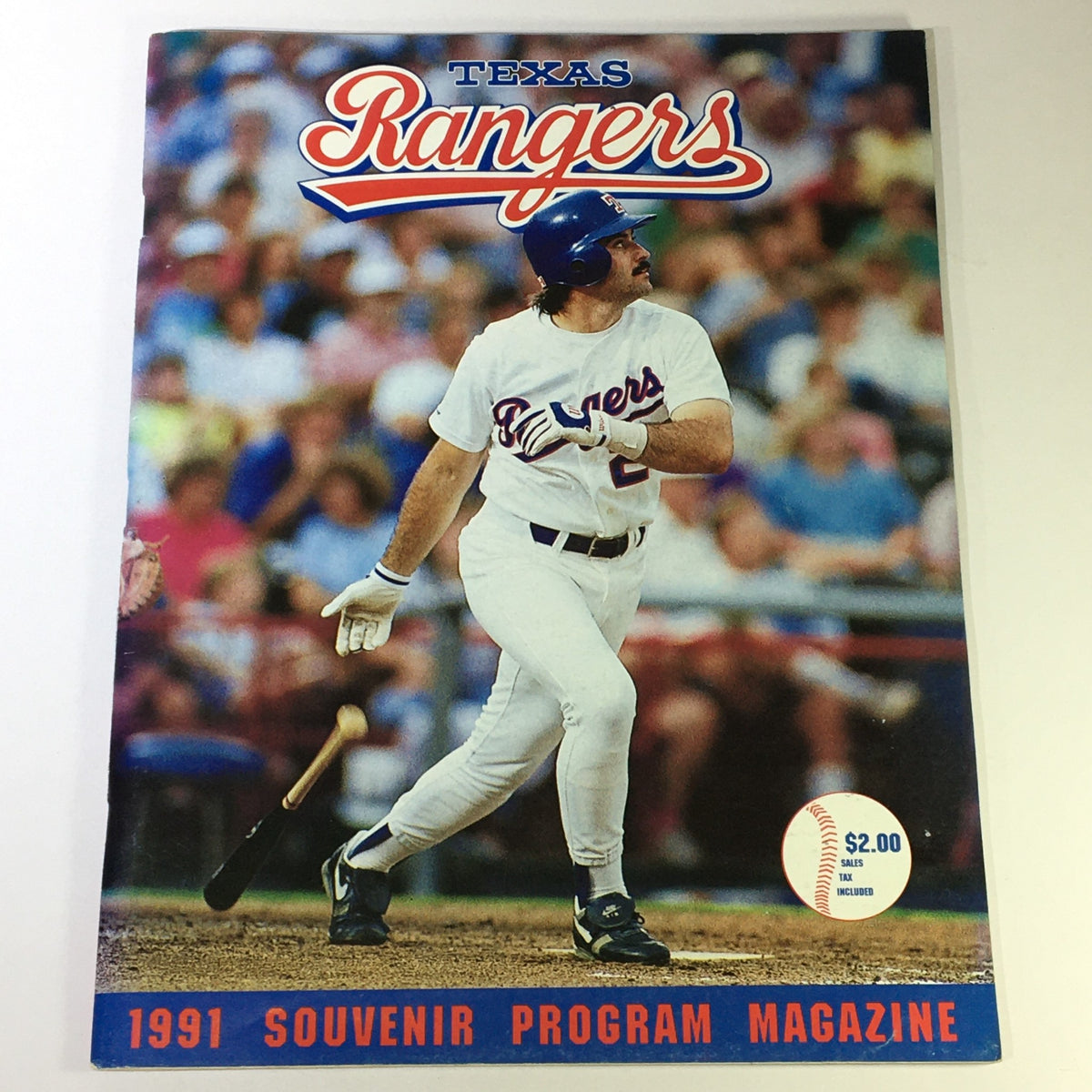 1991 Souvenir Program Magazine featuring the Texas Rangers with a player hitting a baseball, capturing a moment from MLB history.