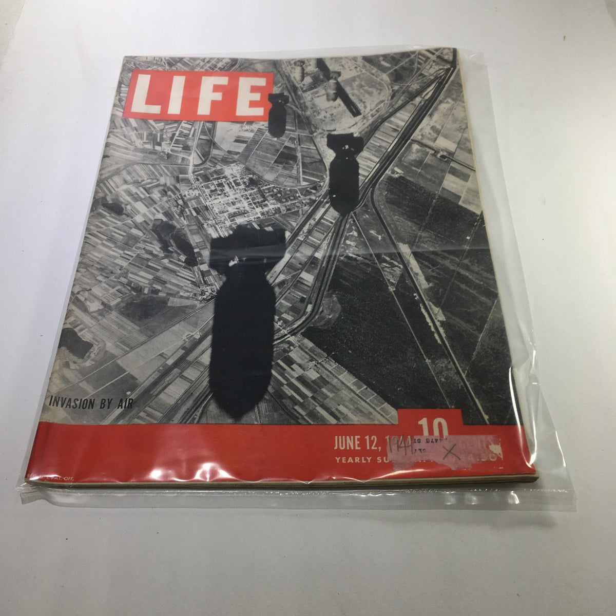 Cover of Life Magazine from June 12, 1944, titled 'Invasion by Air'. The magazine features a black and white aerial photograph, prominently displaying bombs dropping over a landscape, encapsulating a significant World War II moment.