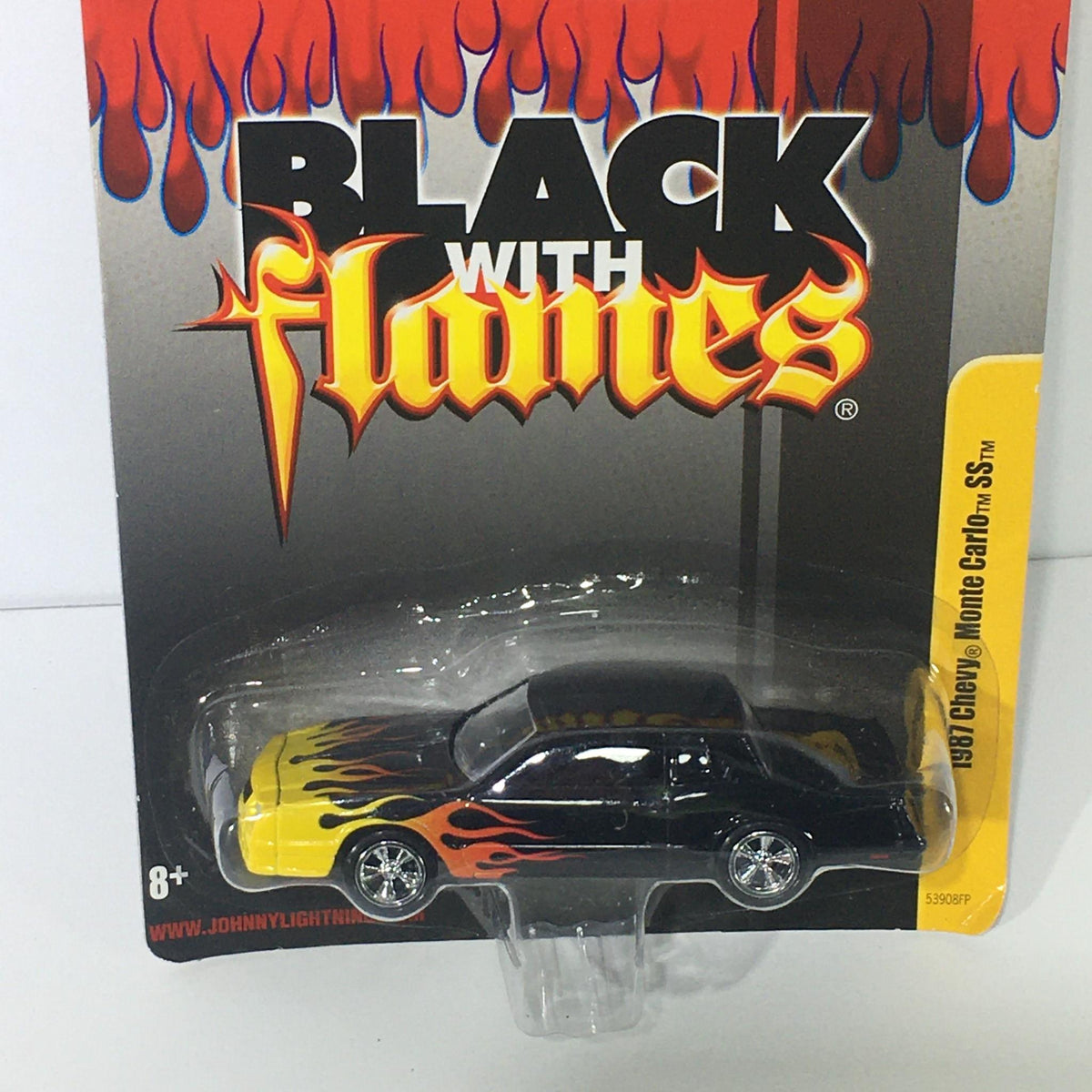 Johnny Lightning Black with Flames 1987 Chevy Monte Carlo SS toy car in blister pack, showcasing bold black and yellow design with flame accents.