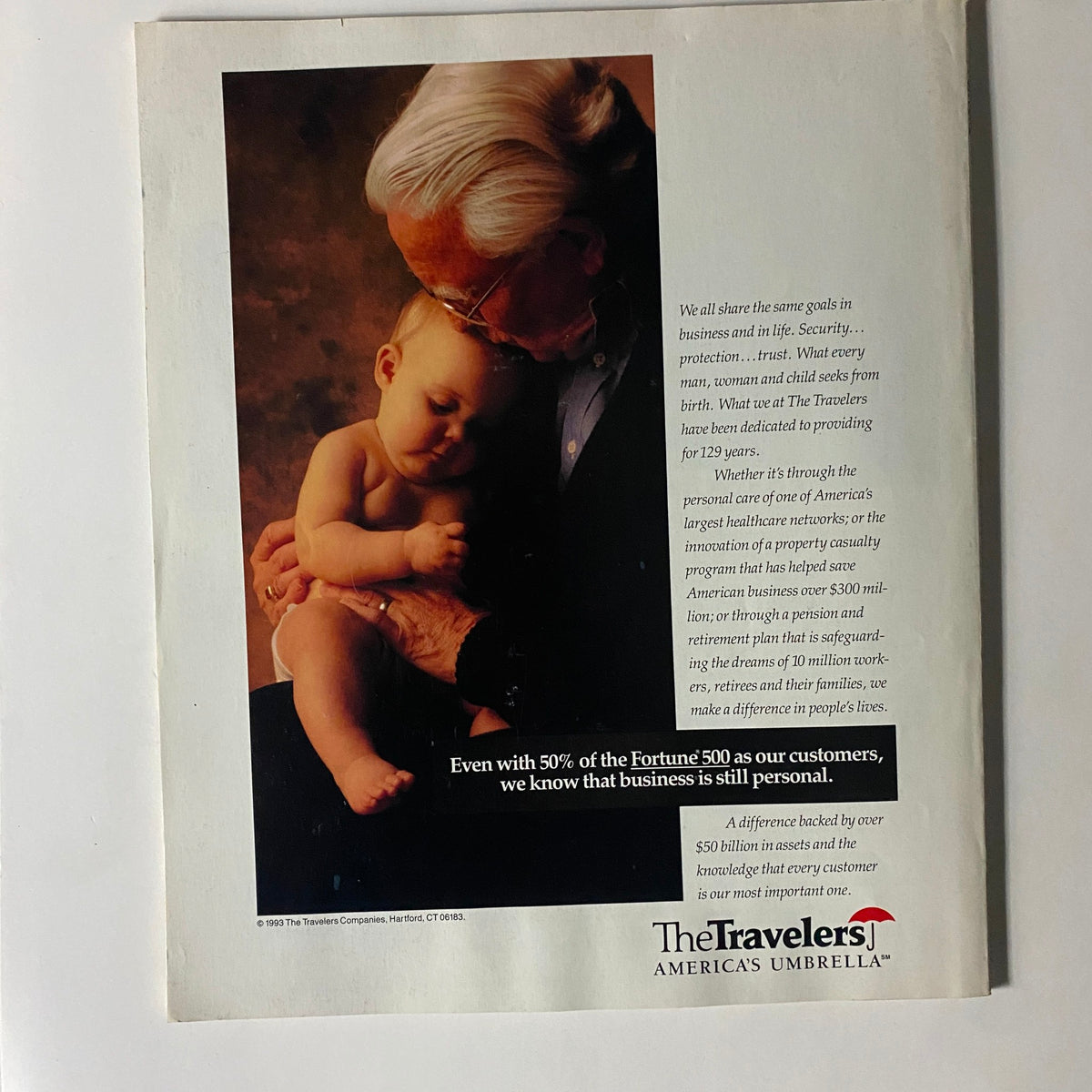 An advertisement from Fortune Magazine, July 12, 1993, featuring an elderly man holding a baby, promoting The Travelers insurance company. The text highlights the importance of personal touch in business, with a focus on security and protection.