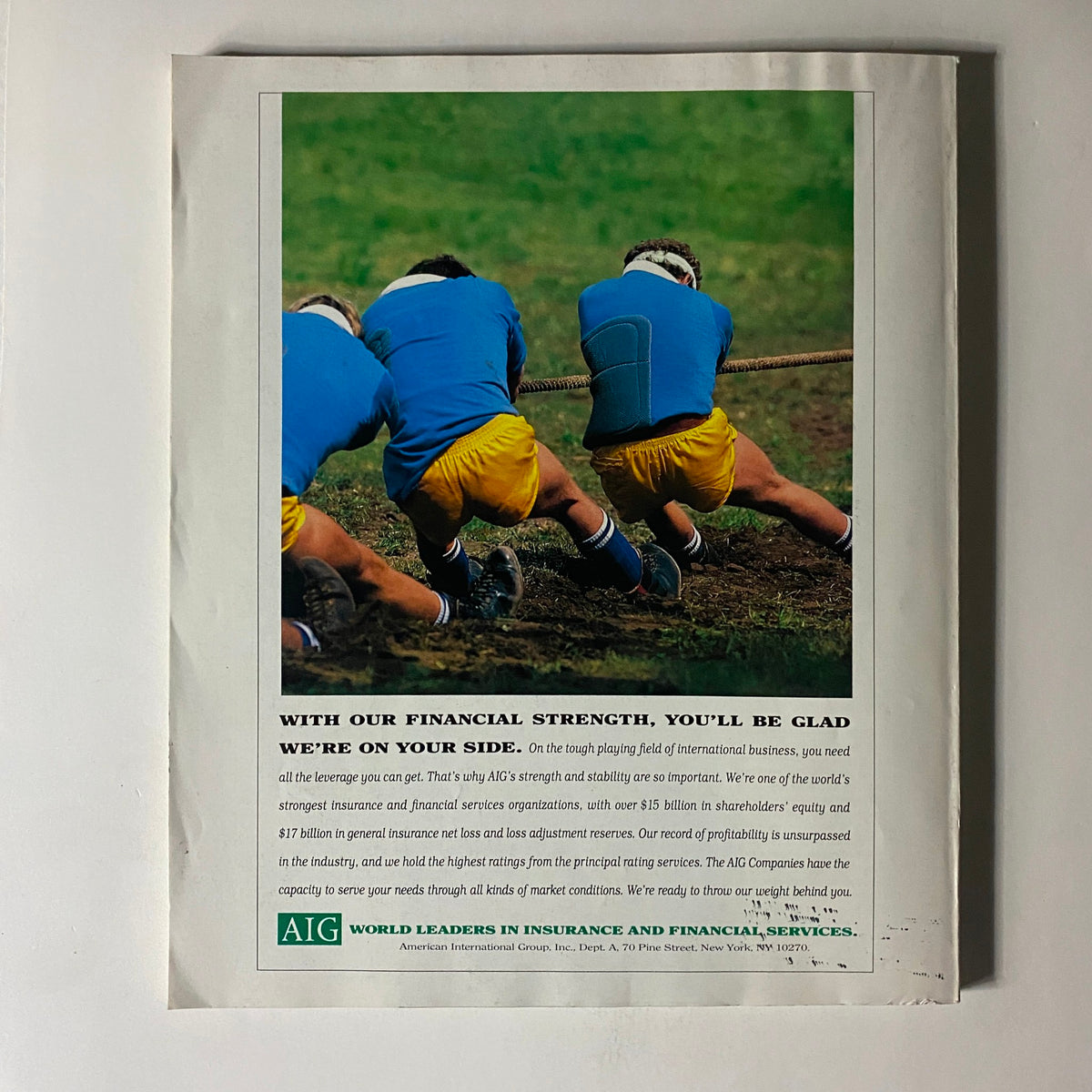 Back cover of Fortune Magazine from July 25, 1994, featuring an advertisement for AIG, emphasizing financial strength with an image of three individuals engaged in a tug-of-war.
