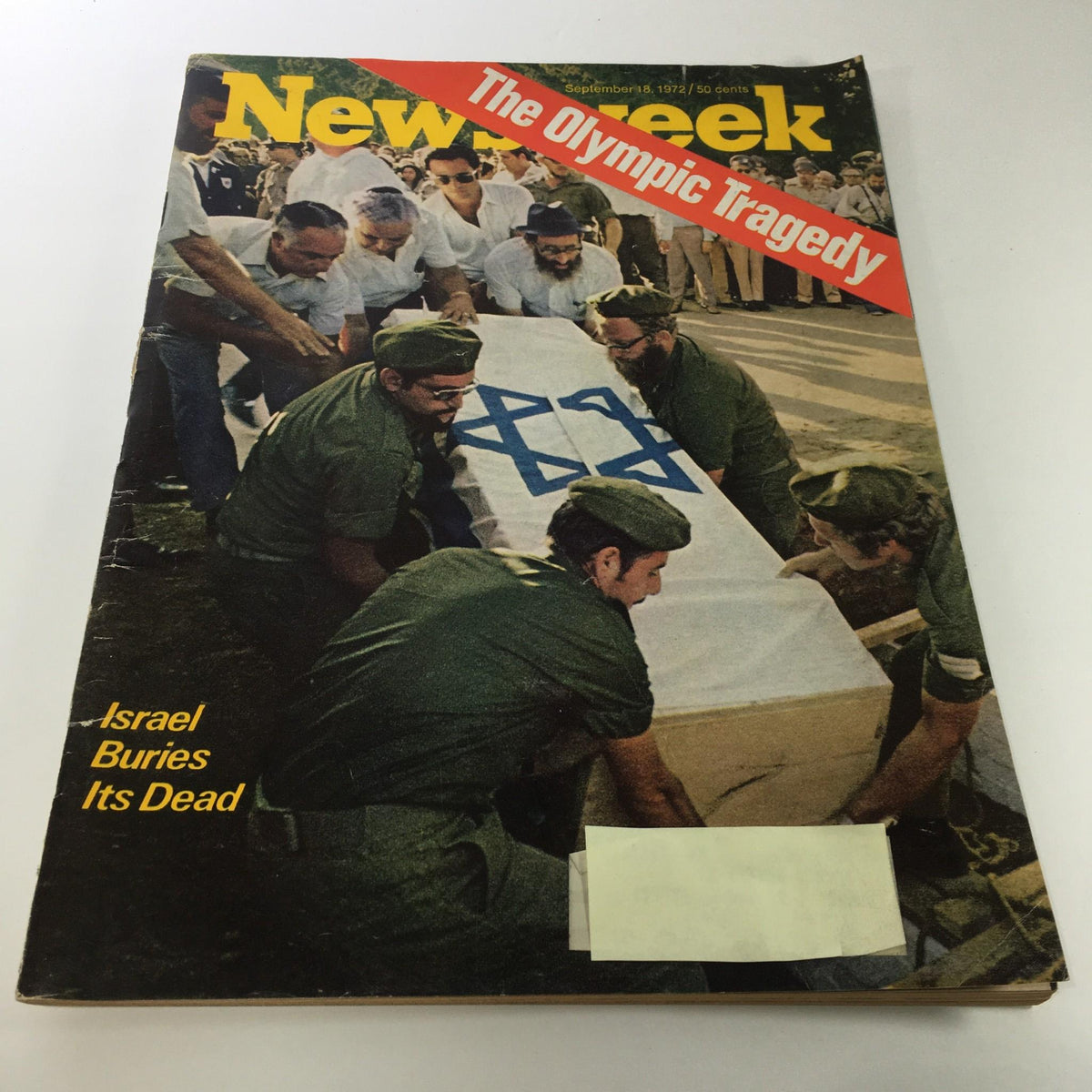 Newsweek Magazine cover from September 18, 1972, featuring the title 'The Olympic Tragedy: Israel Buries Its Dead'. The image depicts individuals in military attire mourning and carrying a flag-draped coffin, symbolizing the aftermath of the tragedy at the 1972 Munich Olympics.