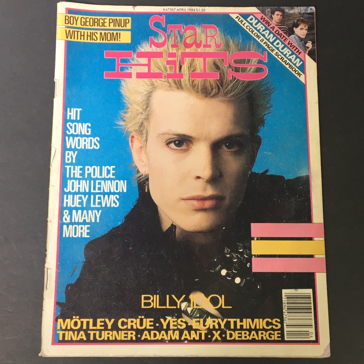 Cover of the VTG Star Hits Magazine from April 1984 featuring Billy Idol, including highlights from rock bands like Mötley Crüe and a tribute to John Lennon. The cover showcases vibrant 1980s pop culture elements and iconic rock music.