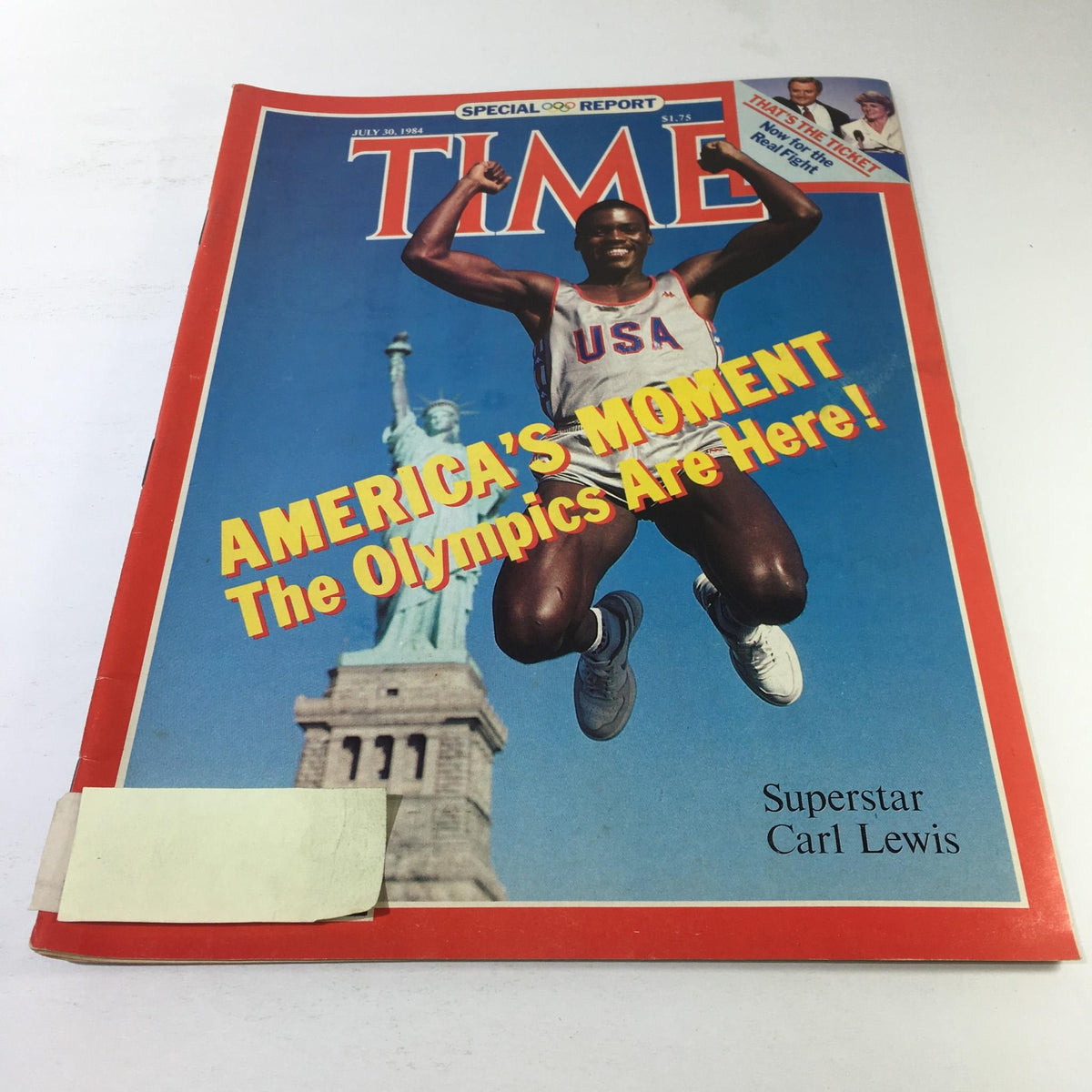 Time Magazine cover from July 30, 1984, featuring Carl Lewis celebrating America's Moment at the Olympics, showcasing the Statue of Liberty in the background.