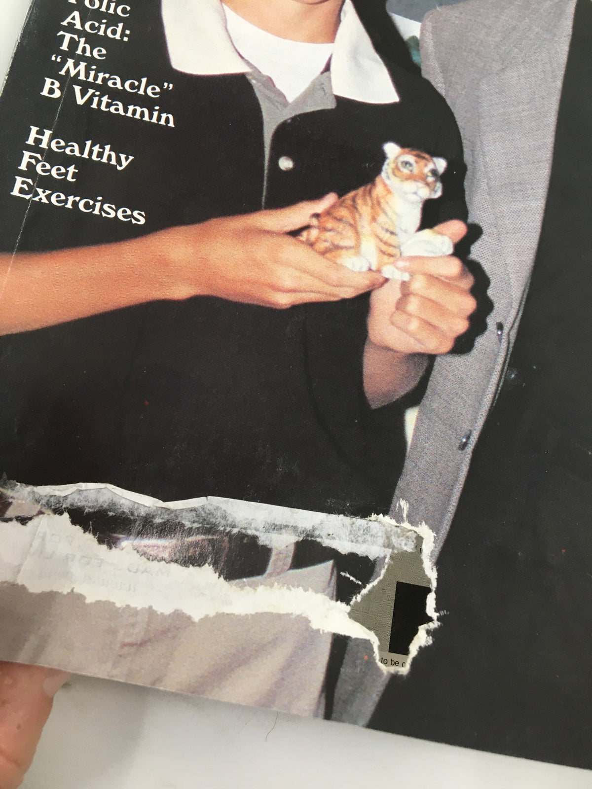 Detail of the cover of The Saturday Evening Post from September 1999, showing a damaged edge and focusing on a young boy with a tiger figurine beside Tiger Woods, capturing the essence of the issue.