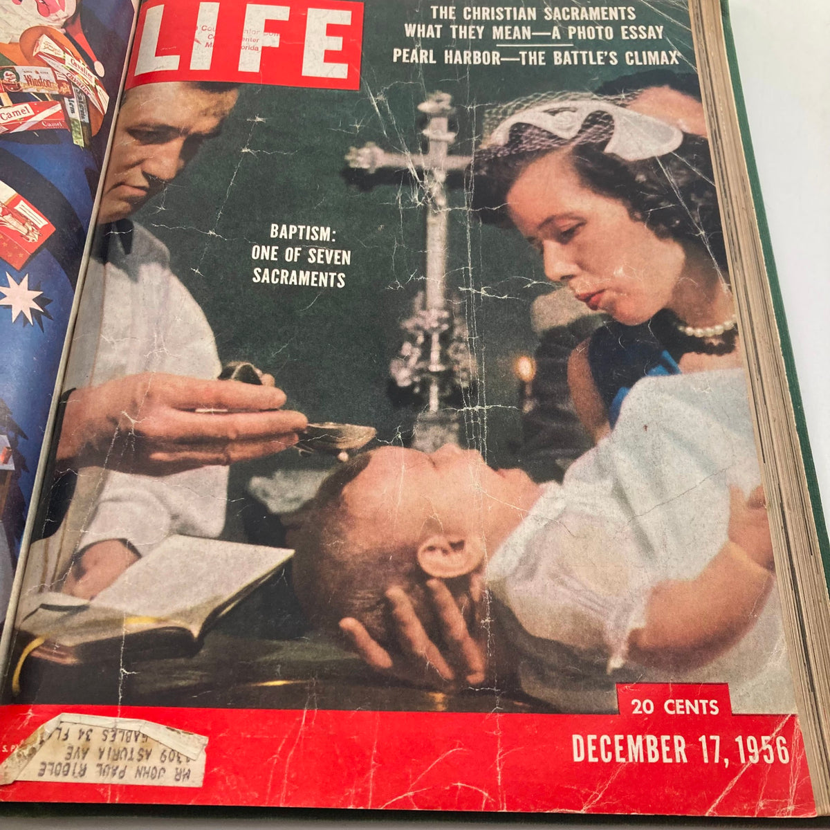Vintage 1956 Bound LIFE Magazine featuring a cover from December 17, 1956, illustrating a baptism sacrament scene with a minister and a woman performing the ritual.