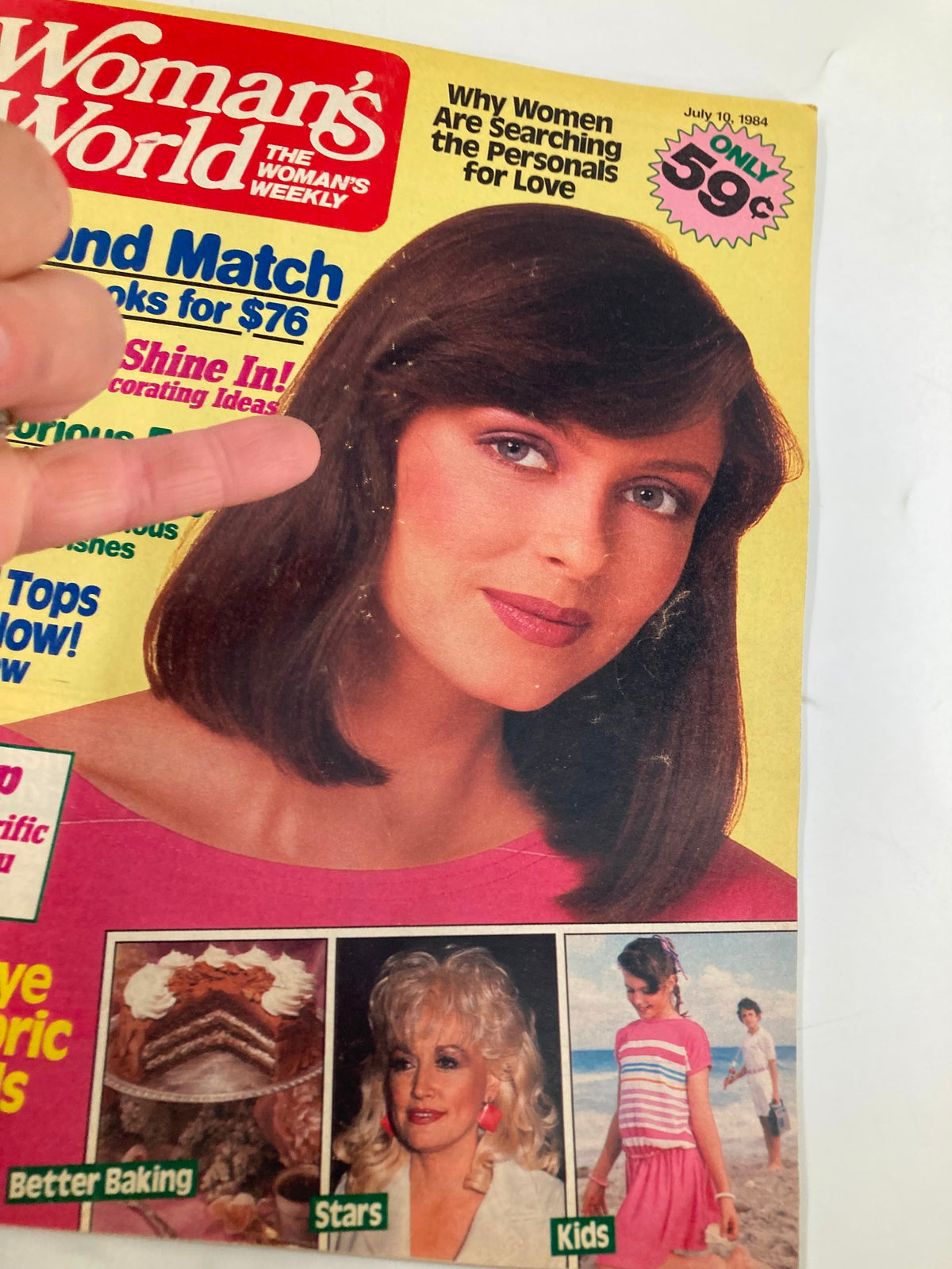 Close-up of Woman's World Magazine July 10 1984 cover highlighting a woman's face with brown hair and colorful headlines regarding personal ads and tie-dyeing fabrics.