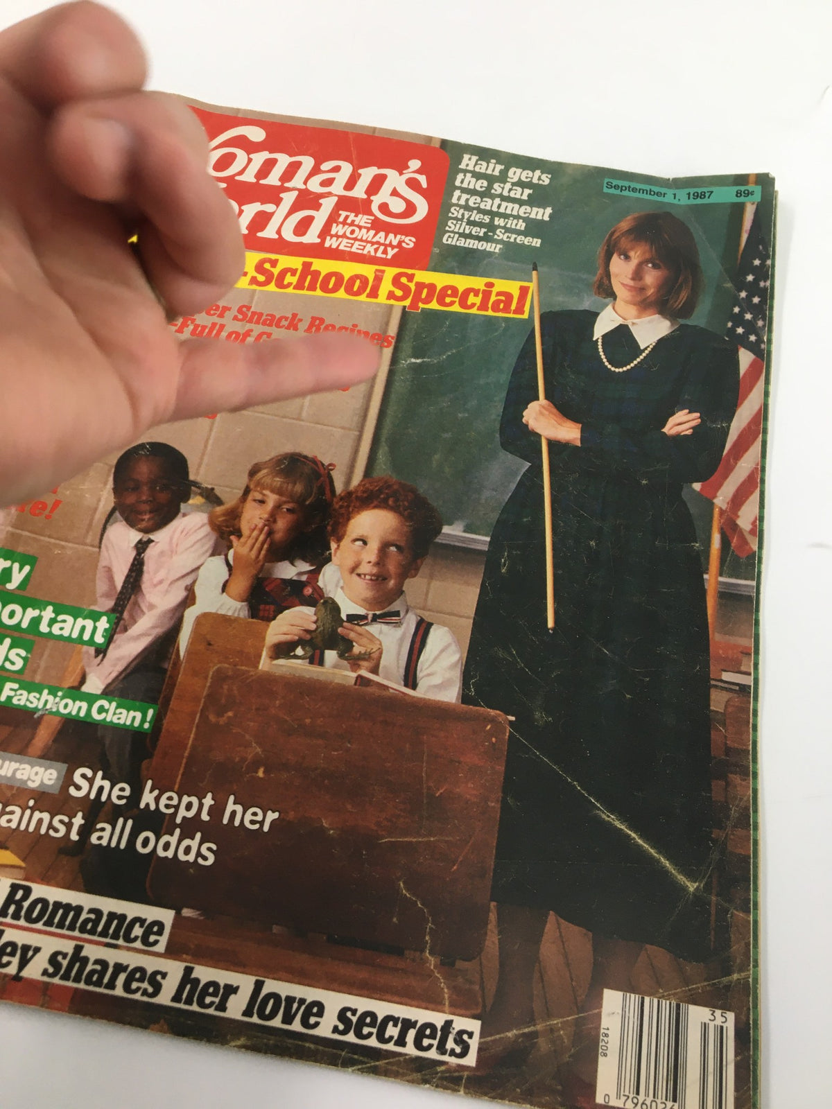 Close-up view of the Woman's World Magazine September 1 1987 cover, showcasing 'Janet Dailey Queen of Romance,' back-to-school topics, and a teacher posing with students in a classroom setting.