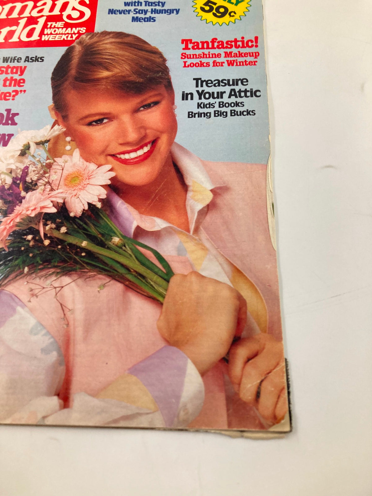 Close-up of Woman's World Magazine January 10 1984 cover highlighting a smiling woman holding flowers, with text about fashion tips and health advice.